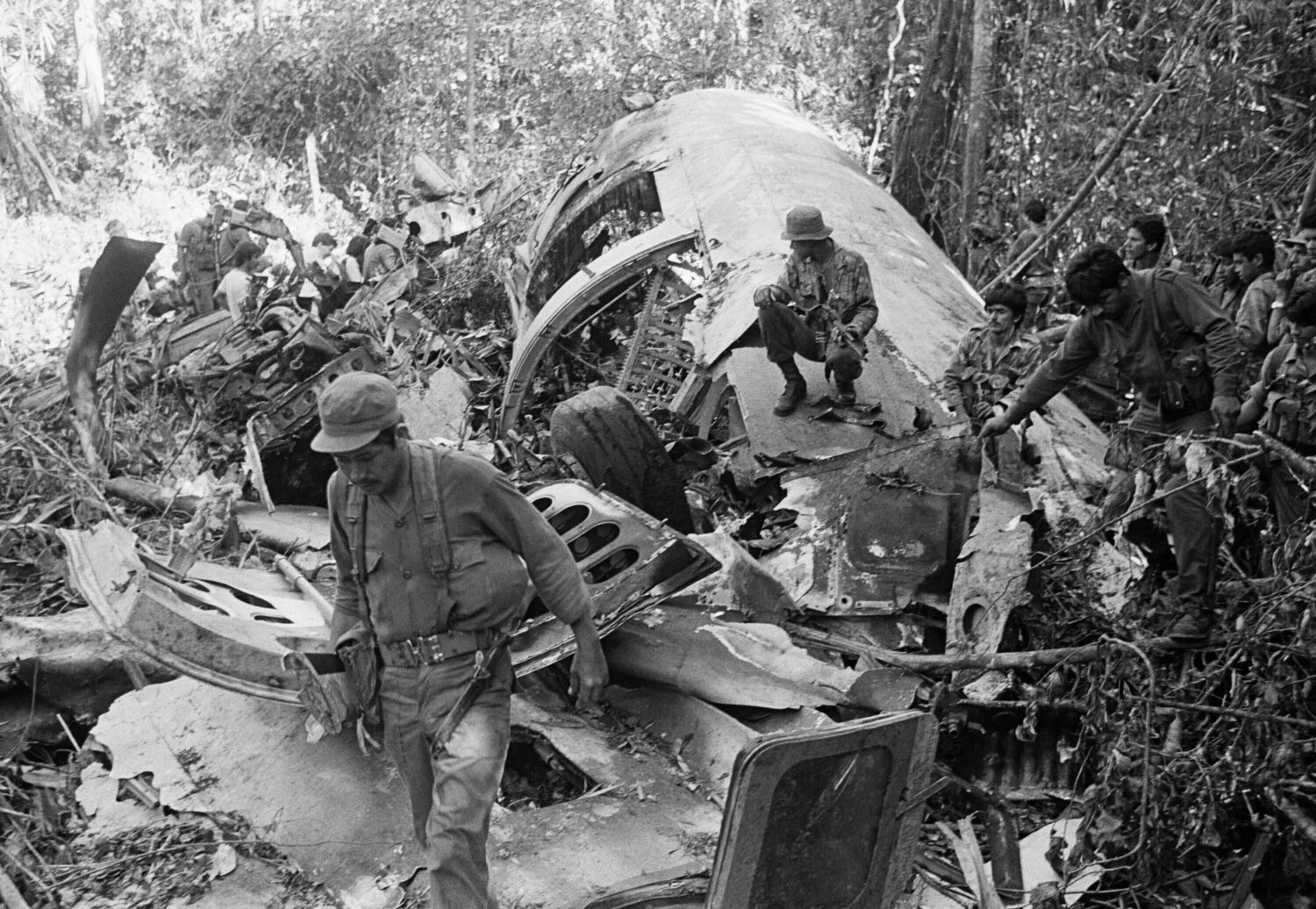 FILE - Sandinista soldiers walk amid the debris after shooting down a supply plane of the U.S.-back...