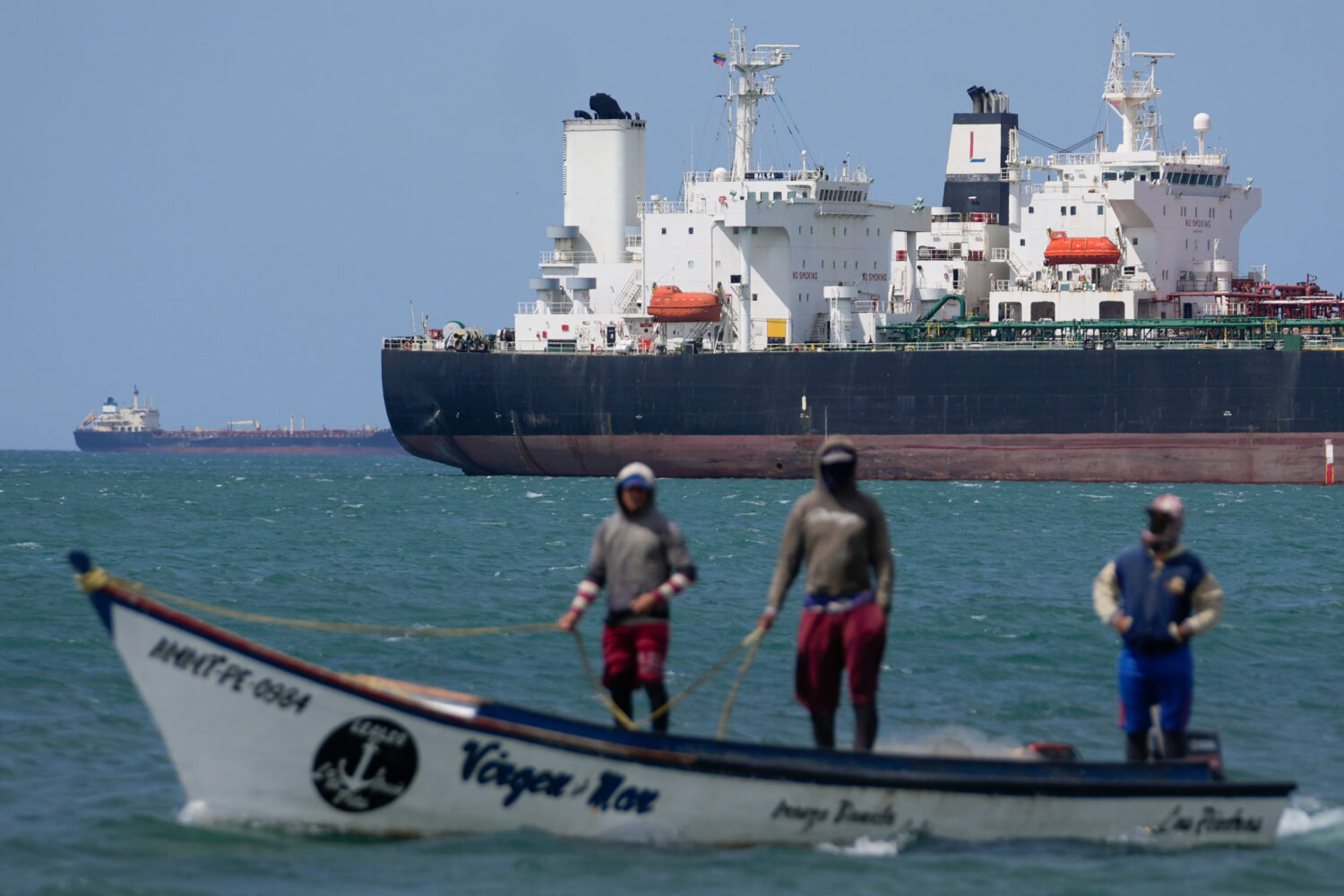 FILE - Fishermen pass an oil tanker in the Gulf of Venezuela off the shore of Punta Cardon, Venezue...