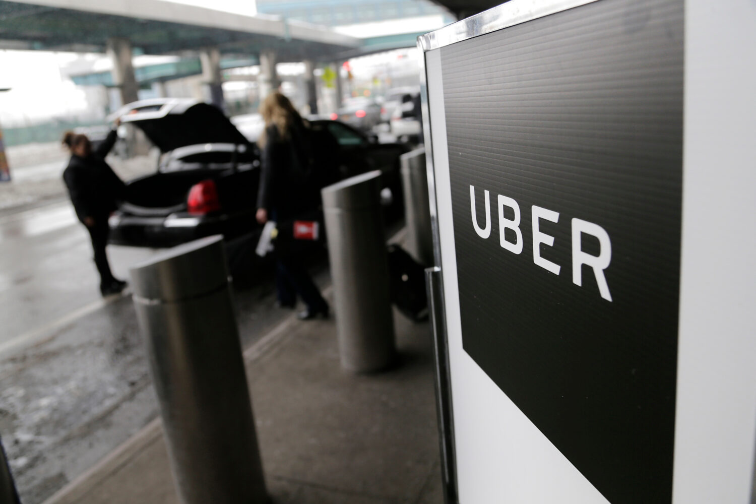 FILE - In this March 15, 2017, file photo, a sign marks a pickup point for the Uber car service at ...