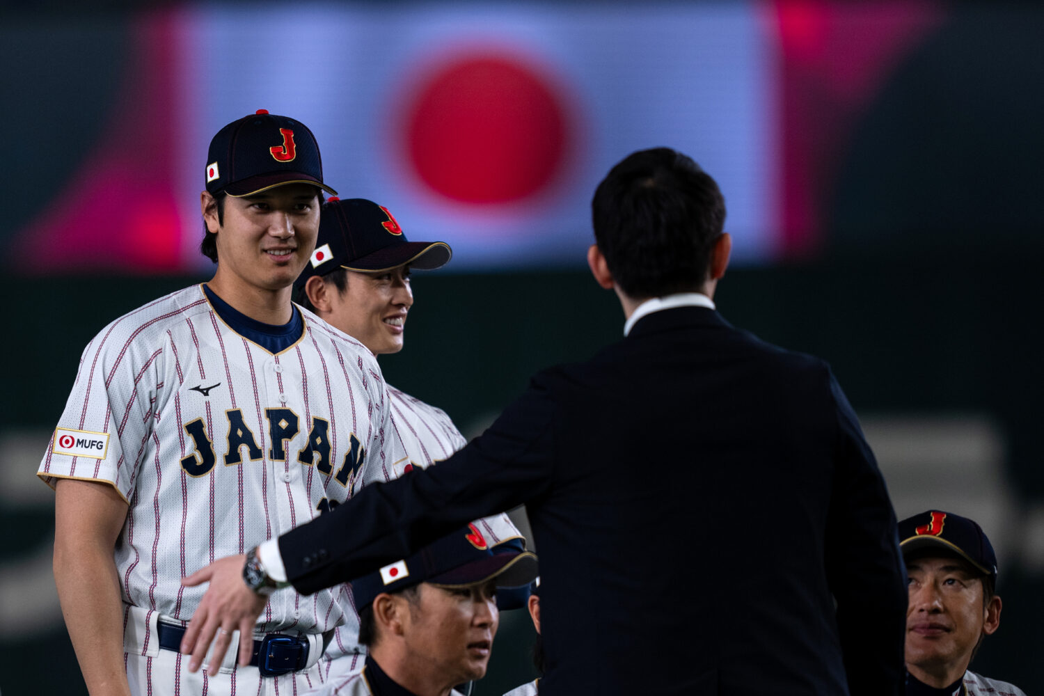 Japan's Shohei Ohtani, left, stands during a group photo session along with other team members befo...