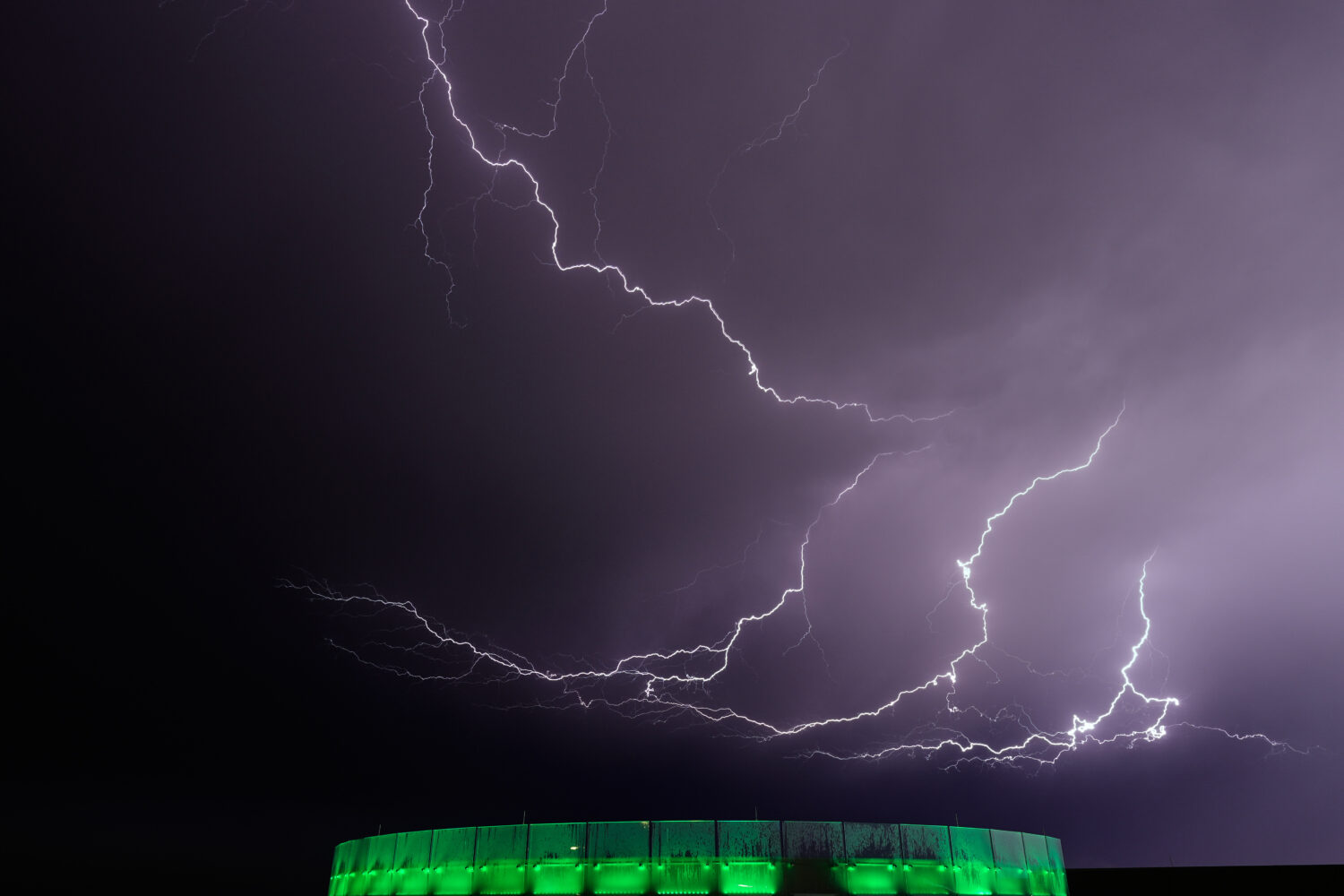 Lightning flashes beyond an office building as a thunderstorm passes in the distance, Monday, April...