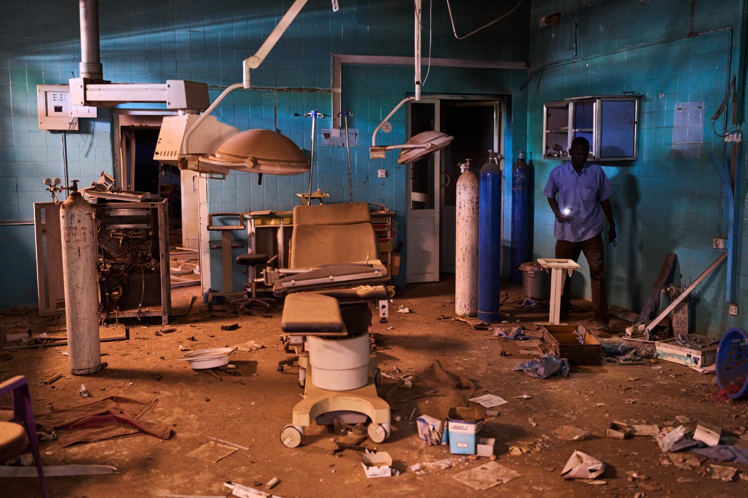 A guard walks through a war-damaged section of Al Shaabi Hospital in Khartoum, Saturday, April 18, ...