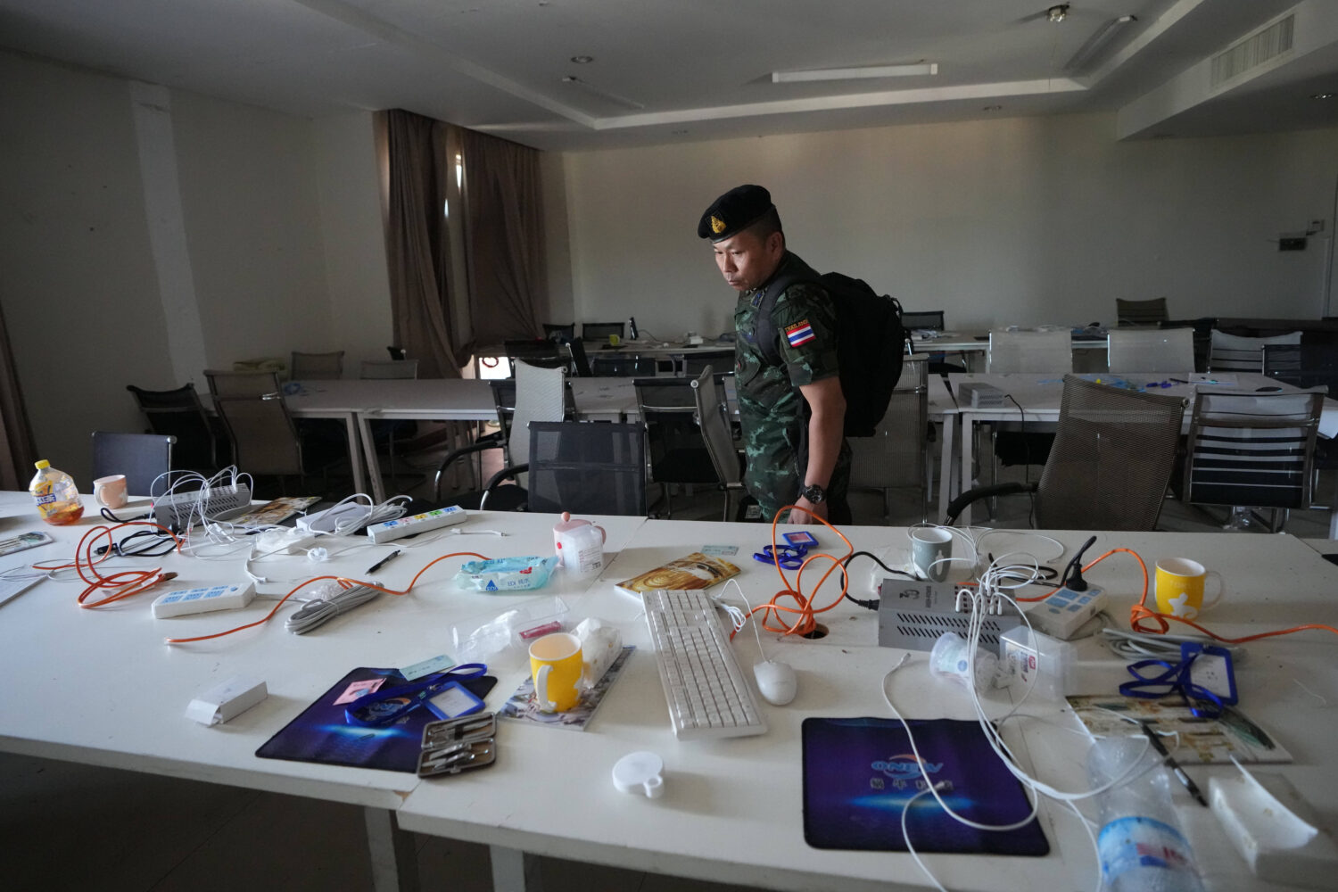 FILE -A Thai solider inspects a work station inside a scam center in O'Smach, Cambodia, Feb. 2, 202...
