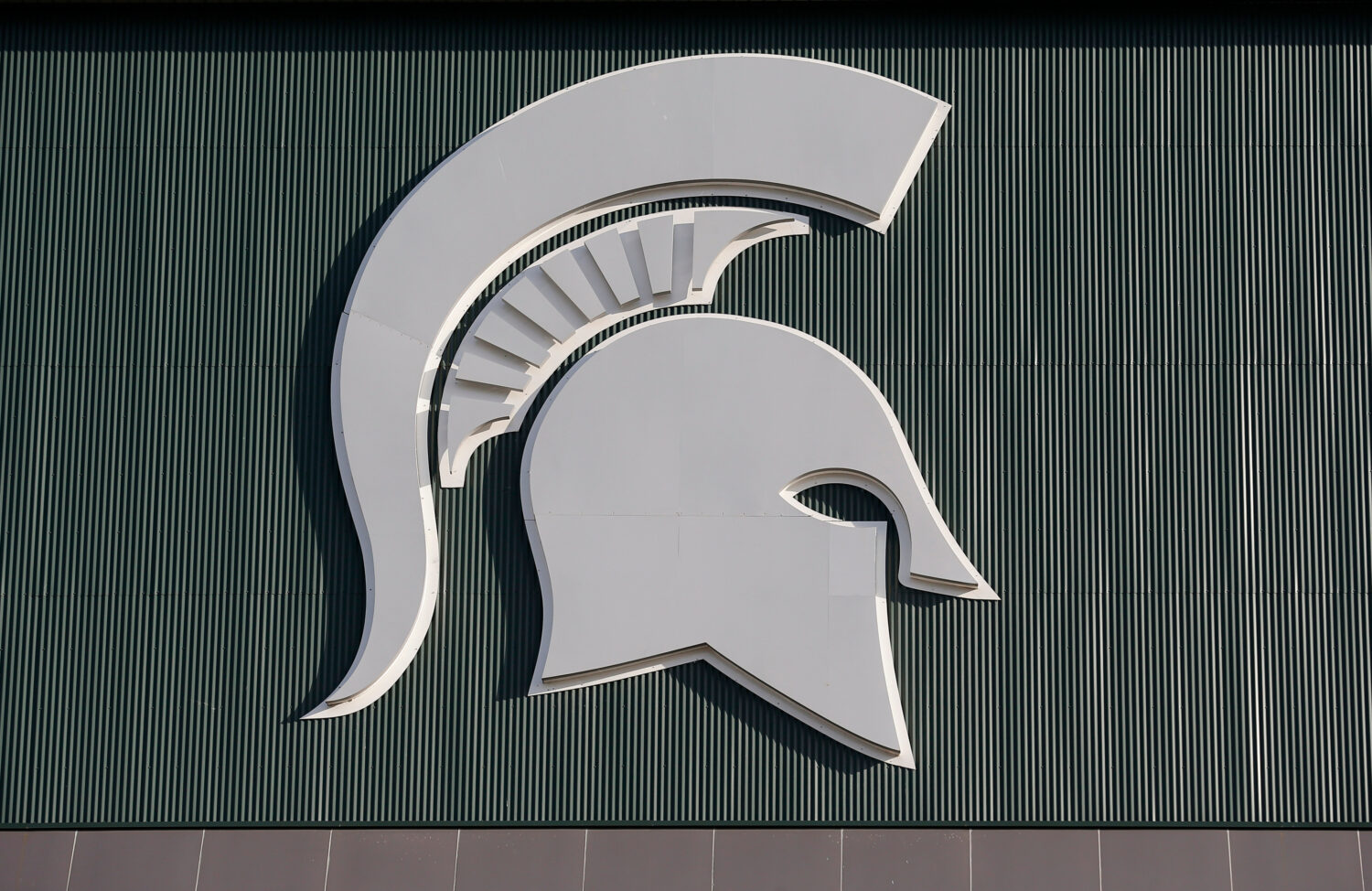 FILE - Michigan State's logo hangs on Spartan Stadium before the start of an NCAA college football ...