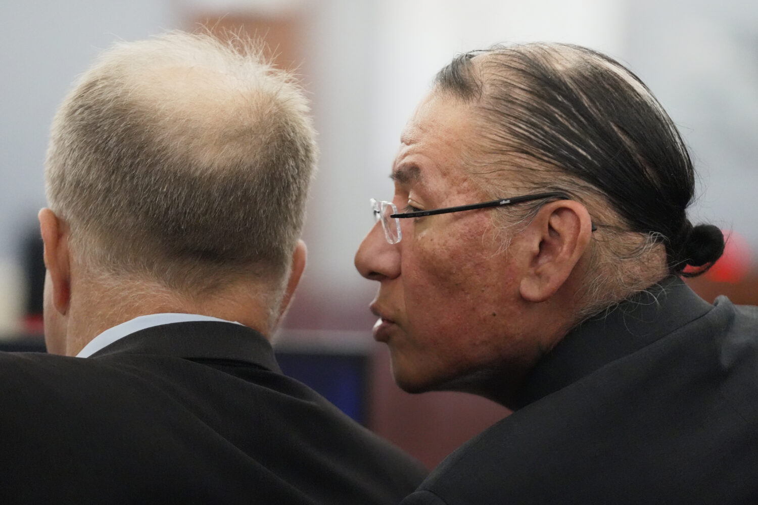 FILE - Nathan Chasing Horse, right, talks to his attorney Craig Mueller during his trial on charges...