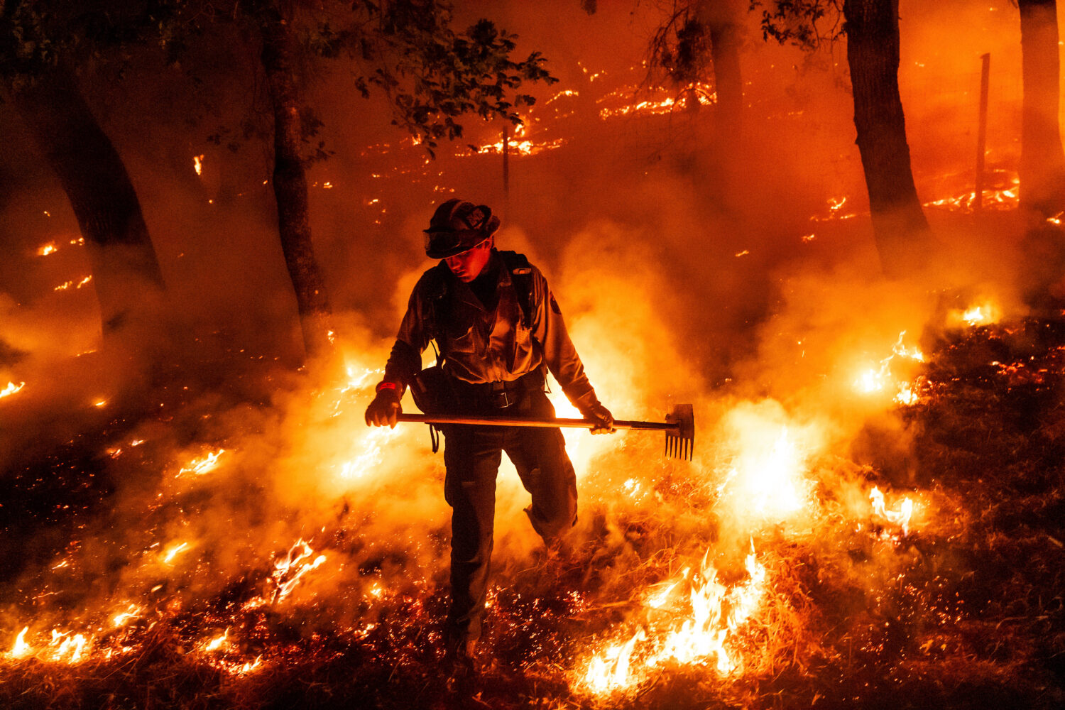 FILE - A firefighter battles the Pickett Fire burning in the Aetna Springs area of Napa County, Cal...