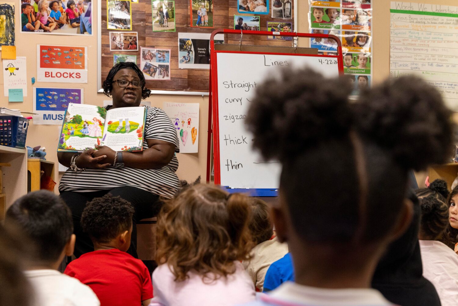 Assistant lead teacher Yolanda Maheia reads a book to a group of preschool students at The Capitol ...