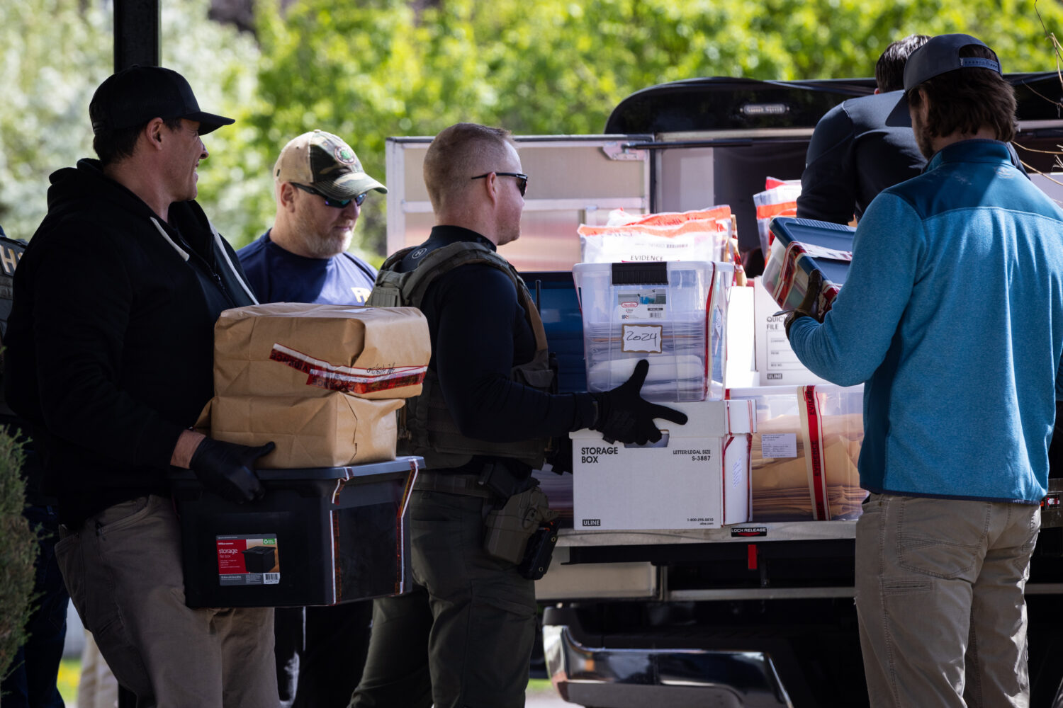 Federal and state officials load evidence into a vehicle as they execute a search warrant at The Or...
