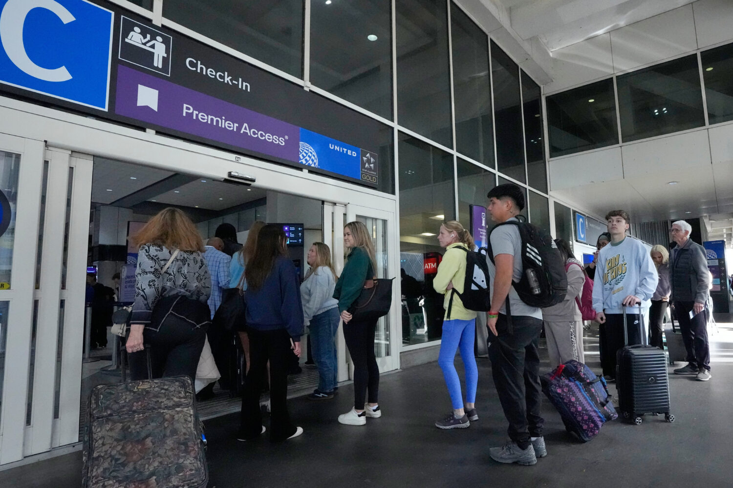 FILE - Passengers wait in long security checkpoint lines outside a terminal at George Bush Intercon...