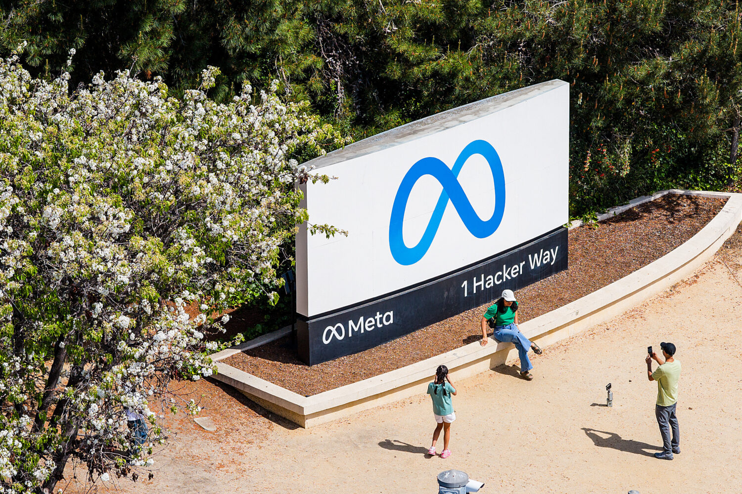 FILE - Visitors take photos at a sign outside Meta headquarters March 26, 2026, in Menlo Park, Cali...