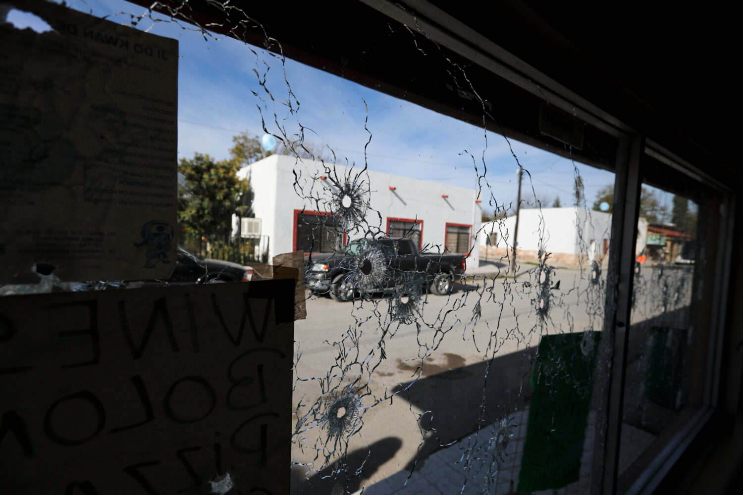 FILE - A shop's windows are riddled with bullets near City Hall after a gun battle between a heavil...