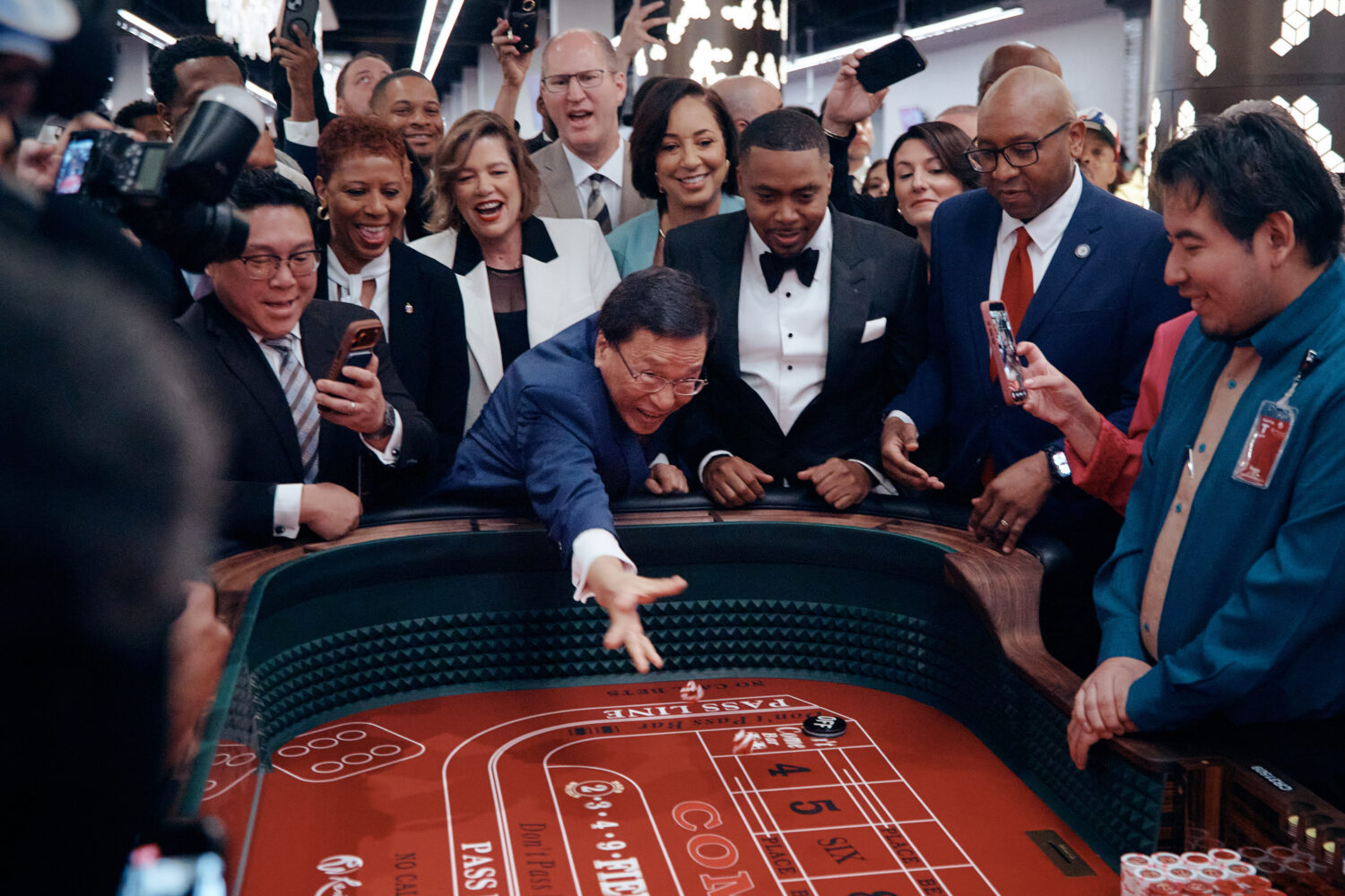 Lim Kok Thay, CEO of Genting Group, center, throws ceremonial dice during the opening of live table...