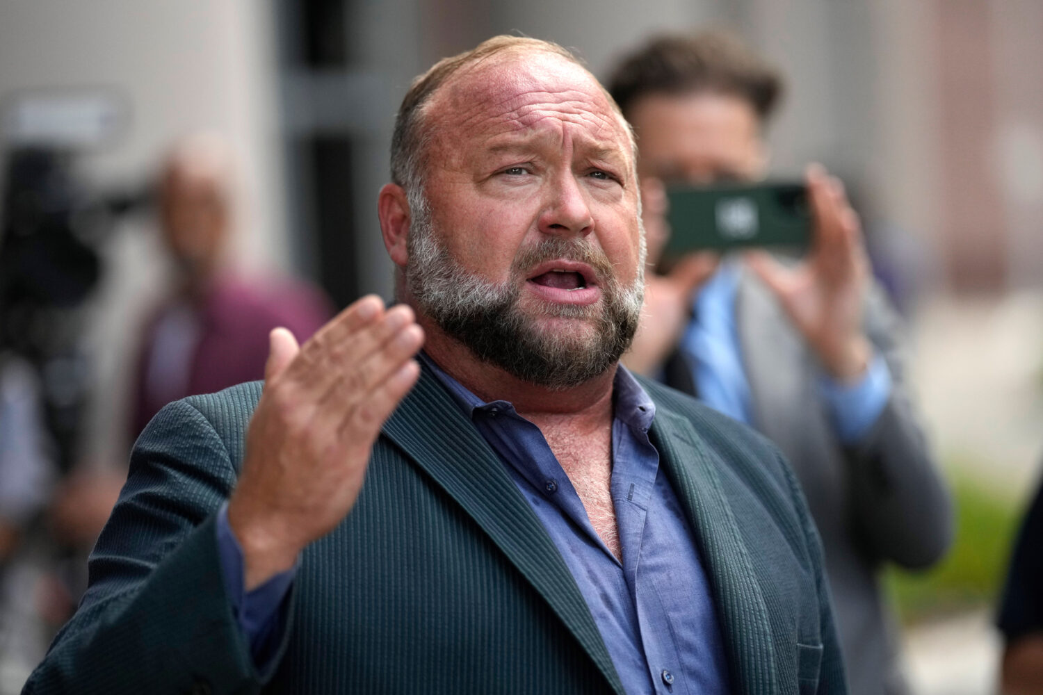 FILE - Right-wing conspiracy theorist Alex Jones speaks to the media after arriving at the federal ...
