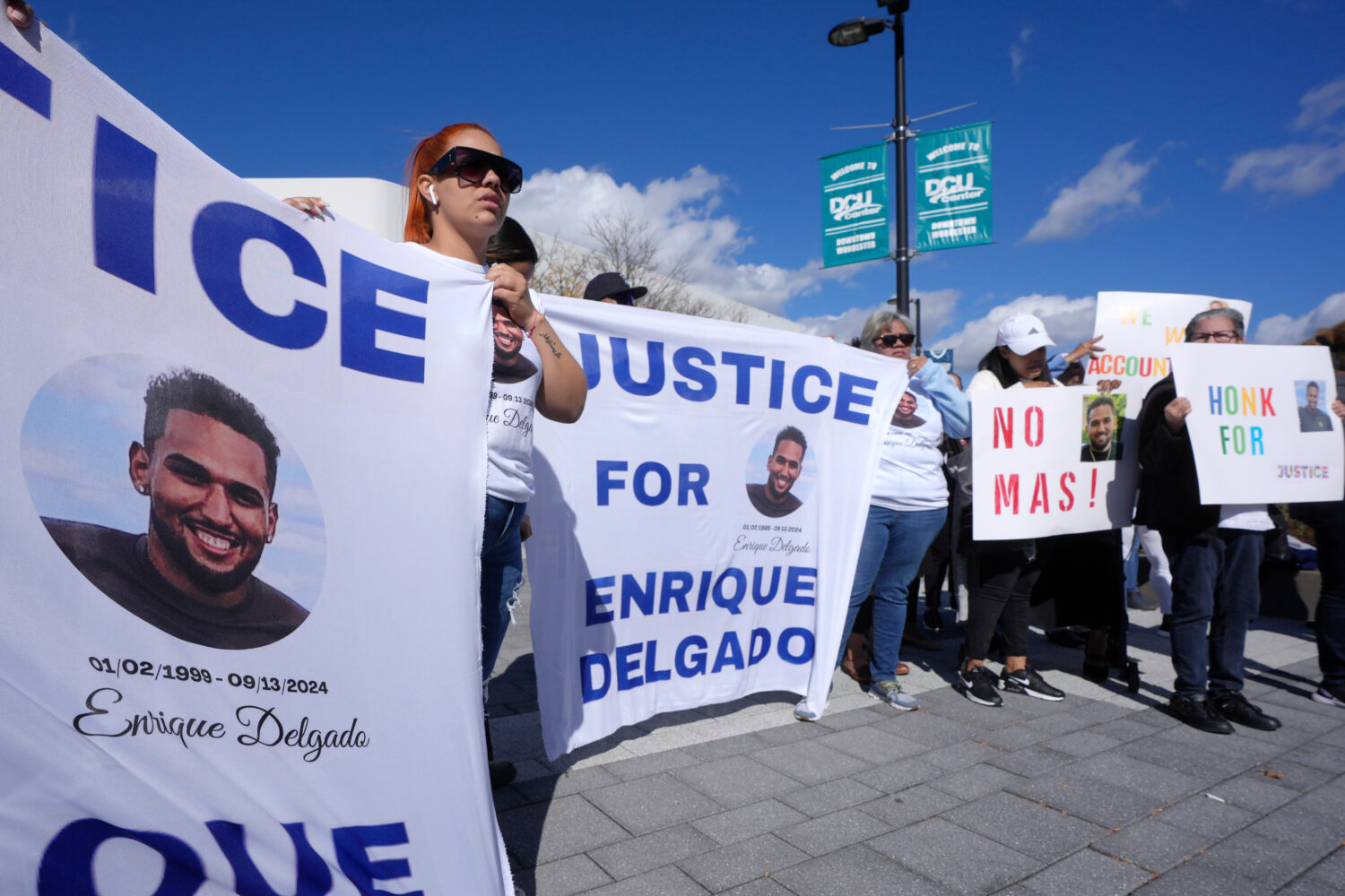 FILE - People display signs with with a likeness of Massachusetts State Police recruit Enrique Delg...