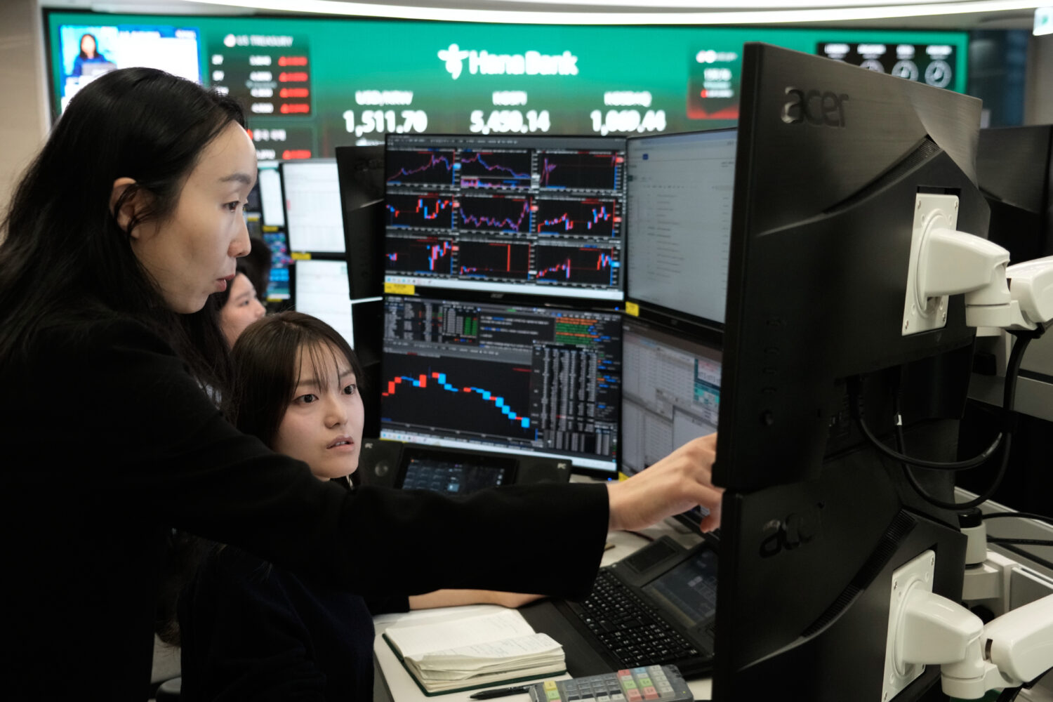 Currency traders watch monitors at the foreign exchange dealing room of the Hana Bank headquarters ...