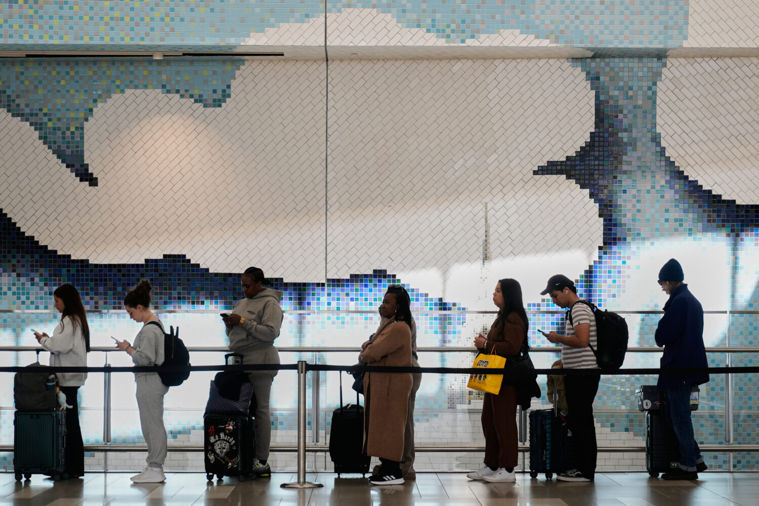 Travelers wait in a lines to get through security at LaGuardia Airport in New York, Monday, March 3...