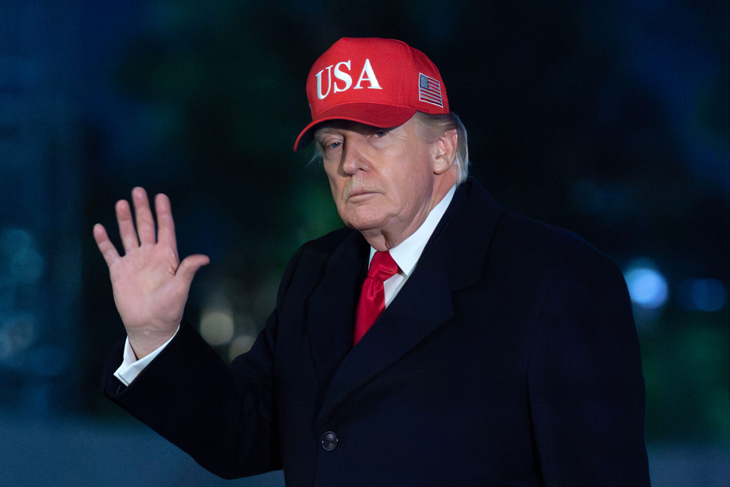 President Donald Trump waves to reporters as he walks on the South Lawn upon his arrival at the Whi...
