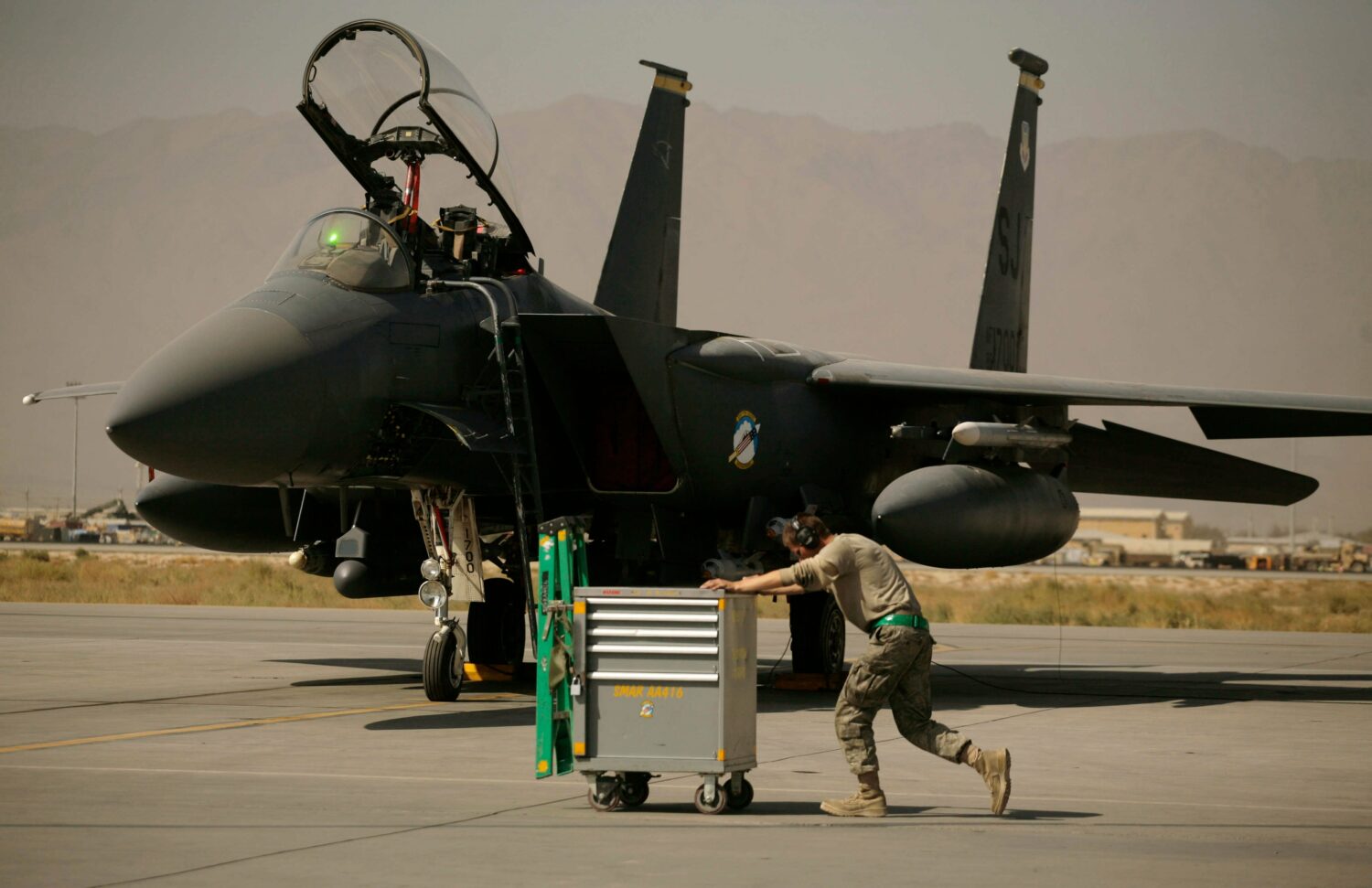 FILE - A U.S. Air Force airman pushes a cart past an F-15E Strike Eagle at Bagram Air Field in Afgh...