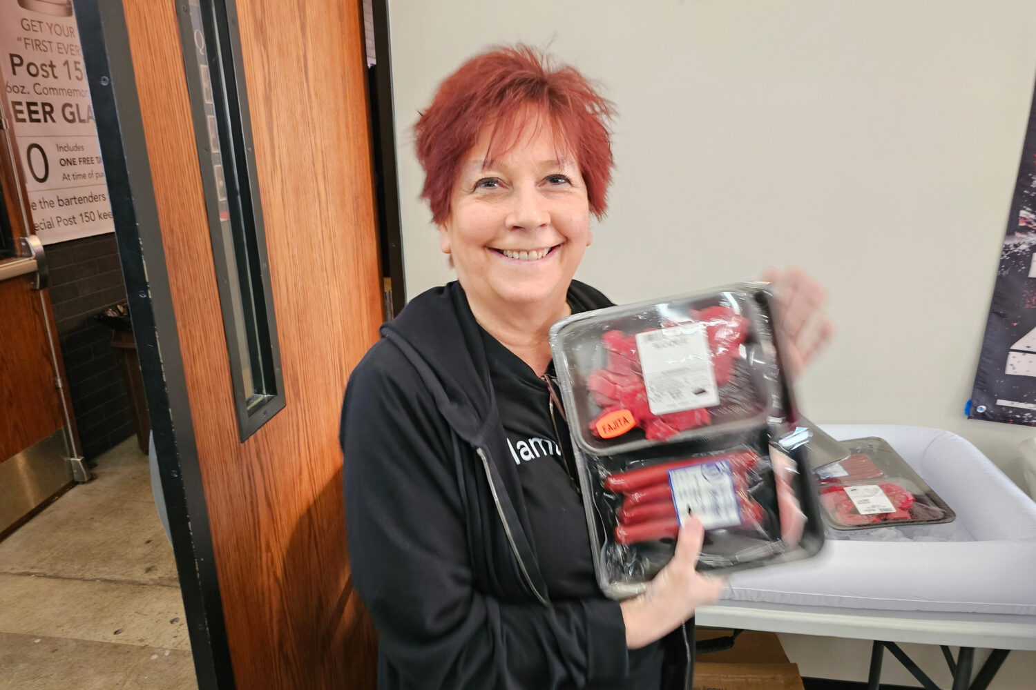Andrea "Mama" Avaloz holds up the package of fajita meat, beef sticks and pork chops that she won i...