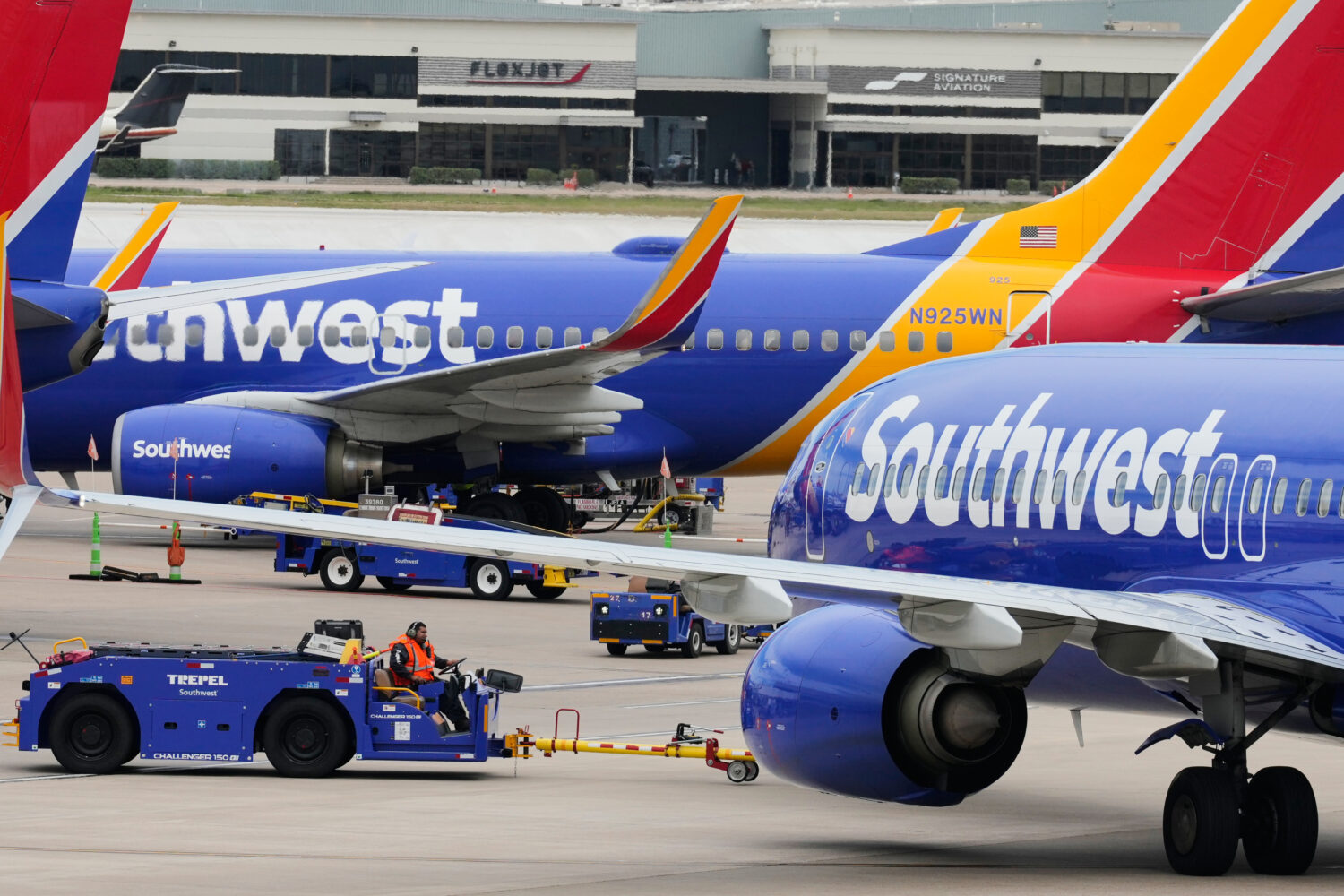 Flight line workers push a Southwest Airlines aircraft away from a gate at Love Field Airport in Da...