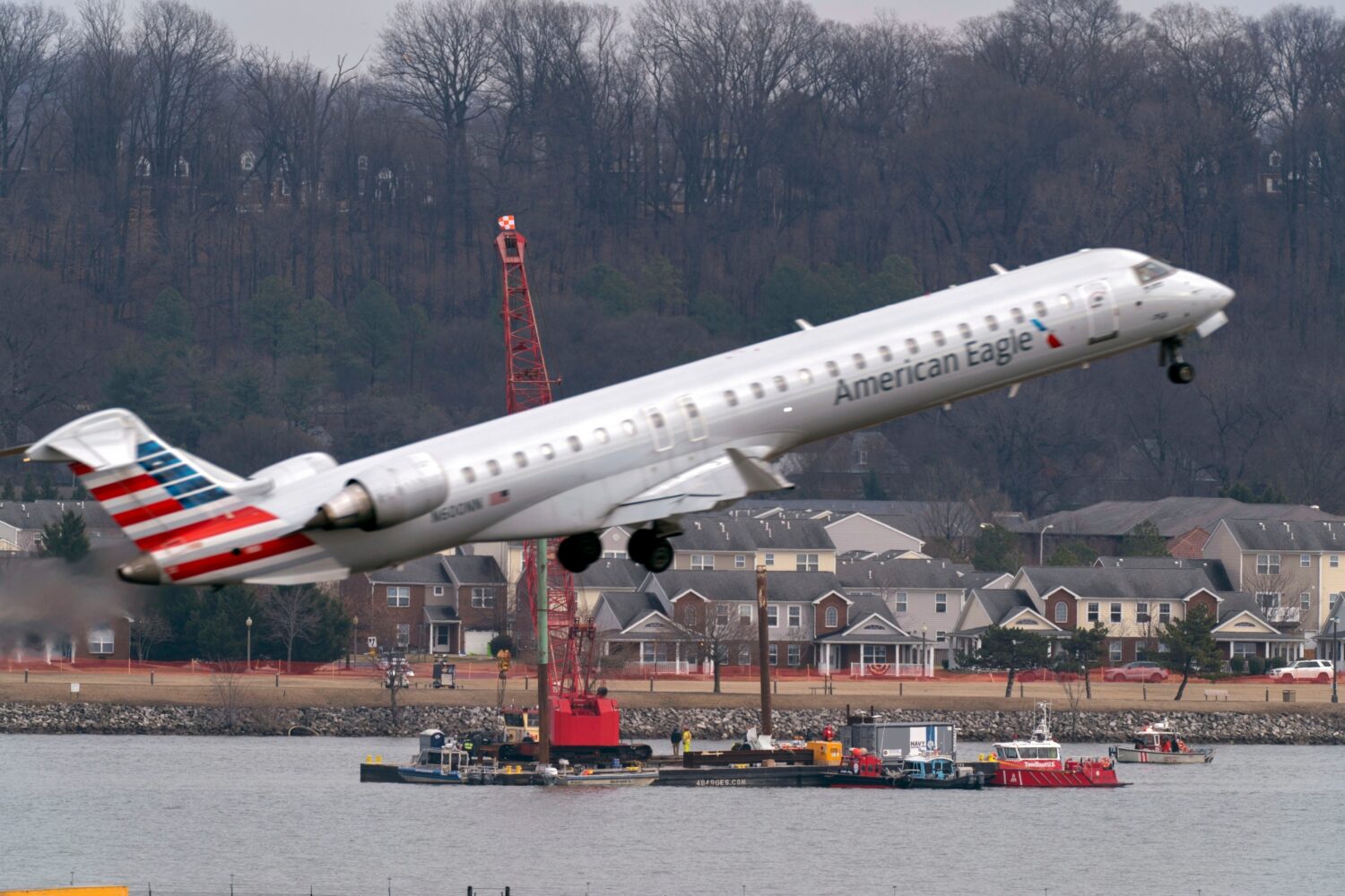 FILE - Salvage crews work on recovering wreckage near the site in the Potomac River of a mid-air co...
