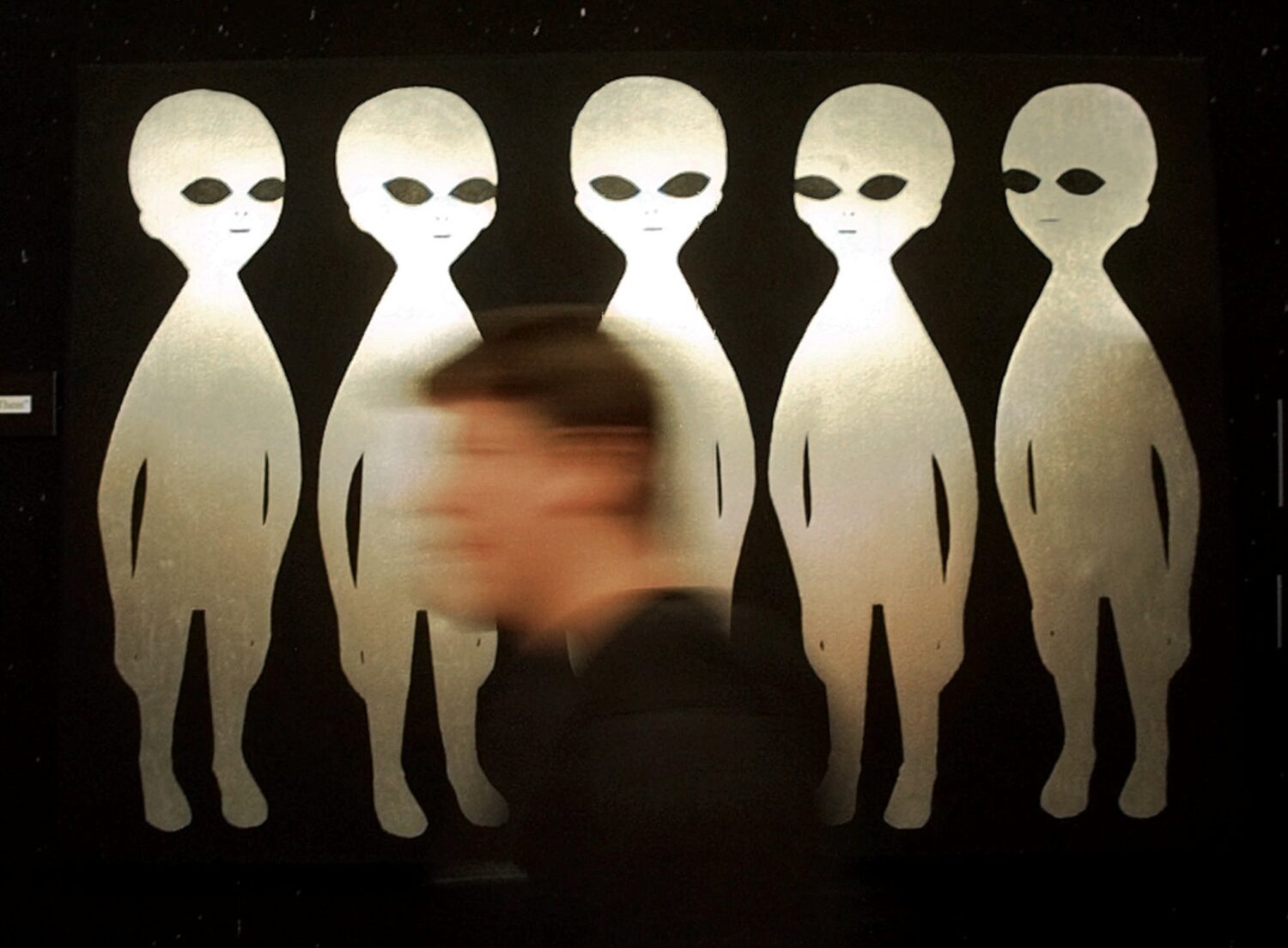 FILE - A patron passes a painting inside the International UFO Museum and Research Center in Roswel...