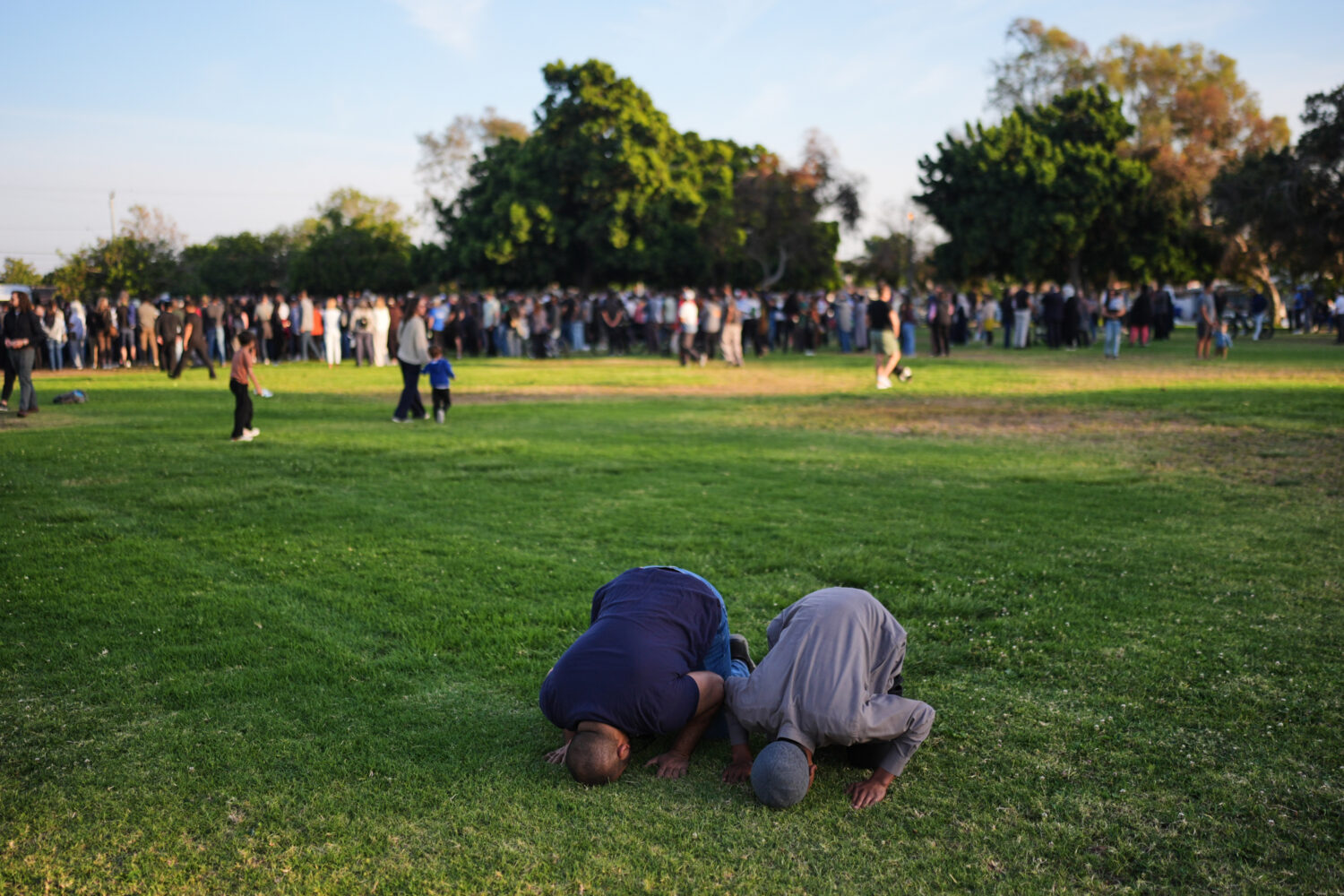 Two people pray during a vigil, the day after a shooting, outside of the Islamic Center of San Dieg...