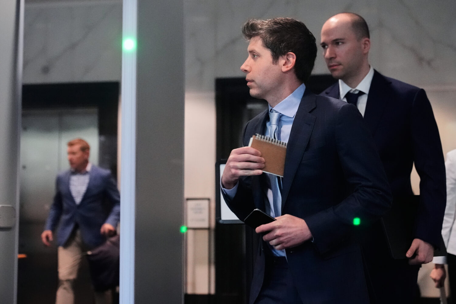 Sam Altman, center, and OpenAI president Greg Brockman, right, arrive at the U.S. District Court in...