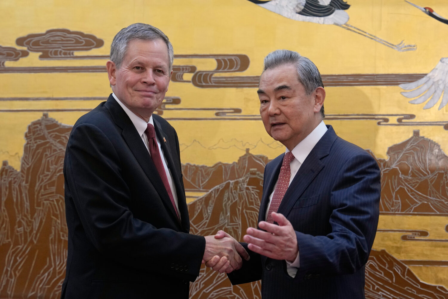 U.S. Senator Steve Daines, left, is greeted by Chinese Foreign Minister Wang Yi during a U.S. congr...