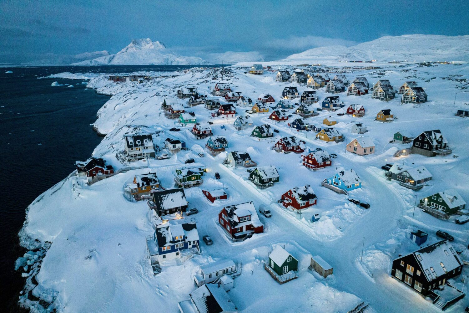 FILE - Houses covered in snow are seen on the coast of a sea inlet of Nuuk, Greenland, Friday, Marc...