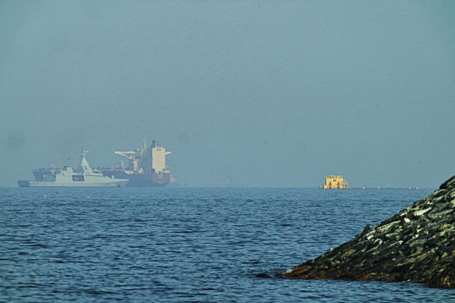 An Emirati patrol boat, left, is near a tanker anchored in the Gulf of Oman near the Strait of Horm...