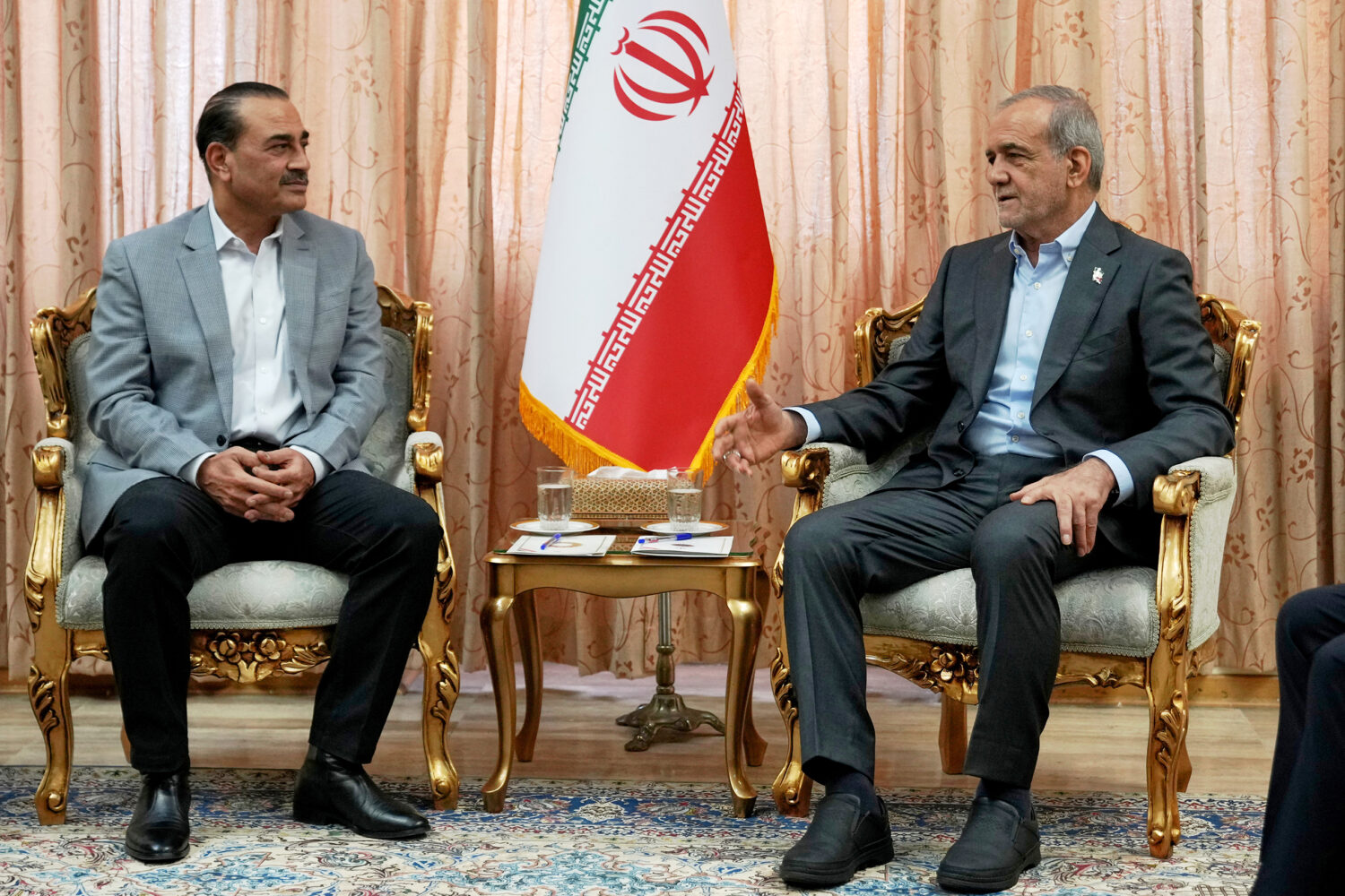 In this photo released by the Iranian Presidency Office, President Masoud Pezeshkian, right, speaks...