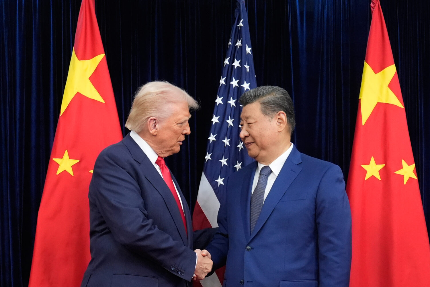 FILE - President Donald Trump, left, and Chinese President Xi Jinping, right, shake hands before th...