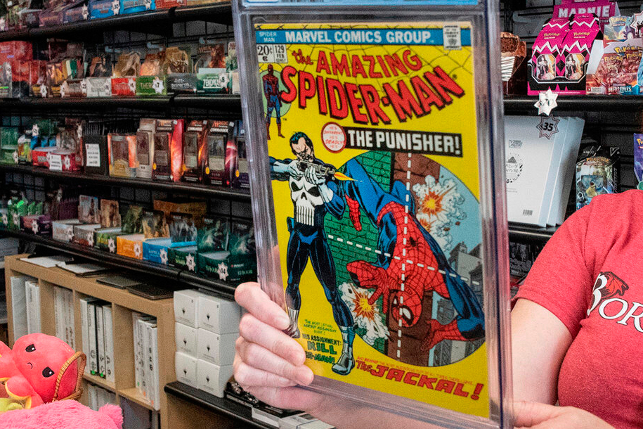 FILE - A game store manager holds the graded AM129 Spiderman "The Punisher" first issue on Sept. 10...