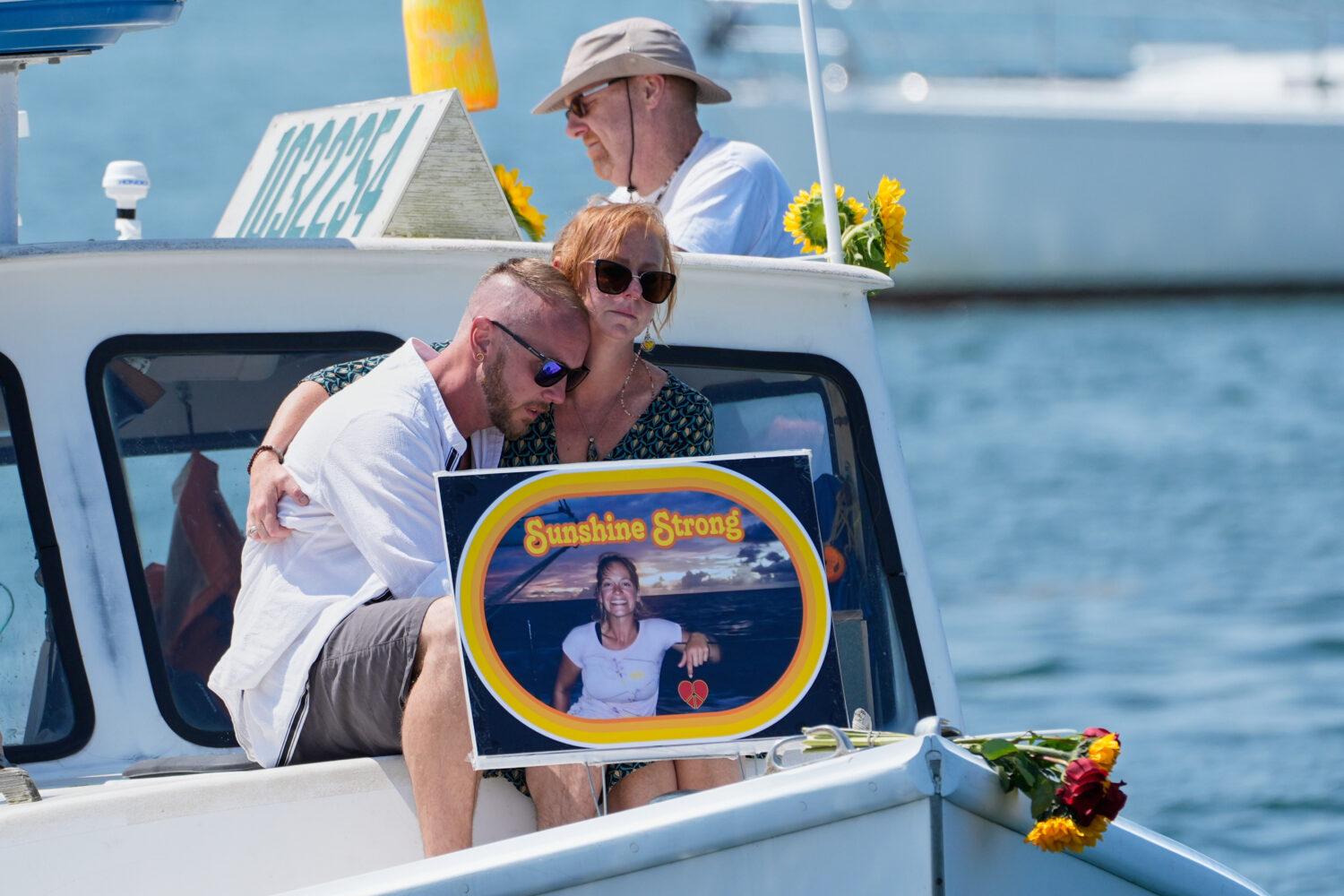FILE - Acquaintances of Sunshine Stewart sit on the bow of a lobster boat during a memorial service...
