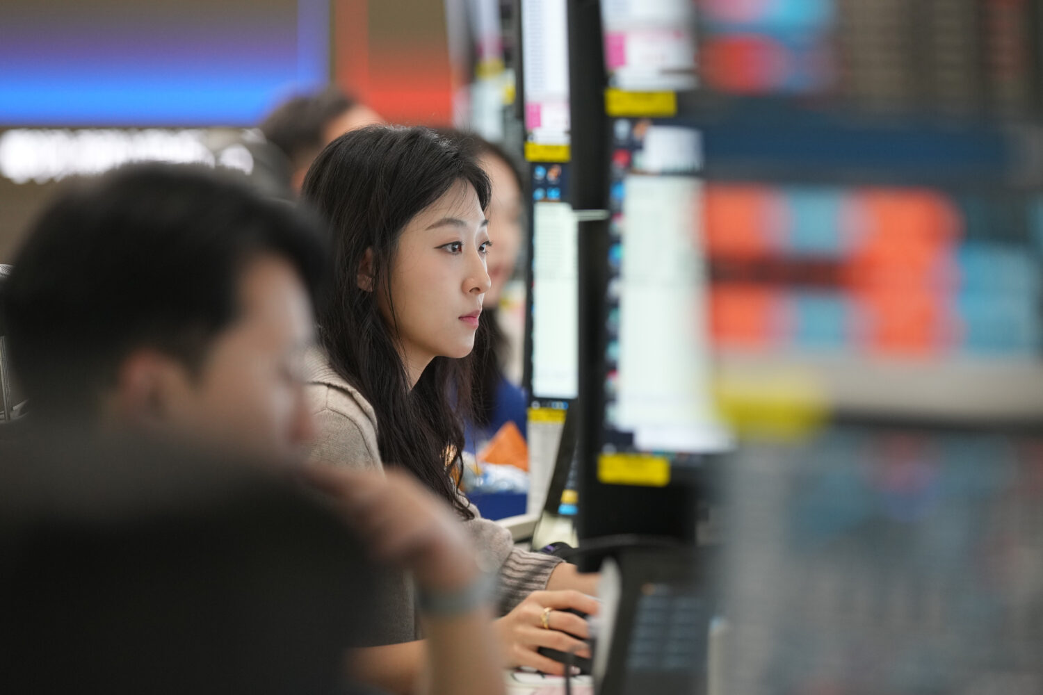 A dealer watches computer monitors at a dealing room of Hana Bank in Seoul, South Korea, Friday, Ma...