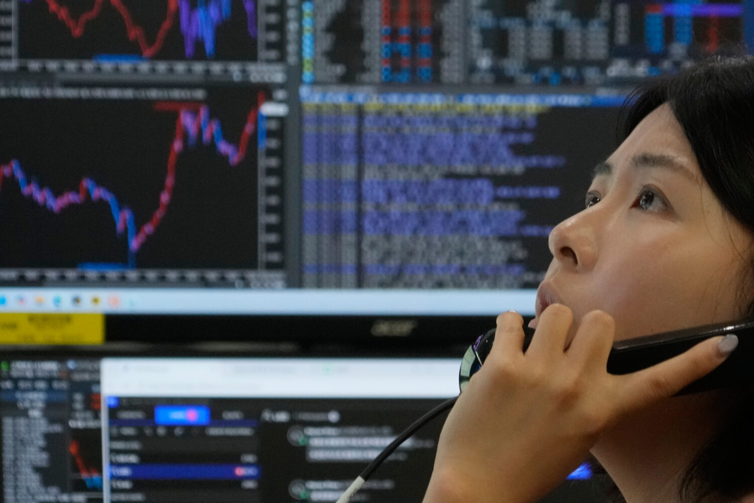 A currency trader talks on the phone at the foreign exchange dealing room of the Hana Bank headquar...
