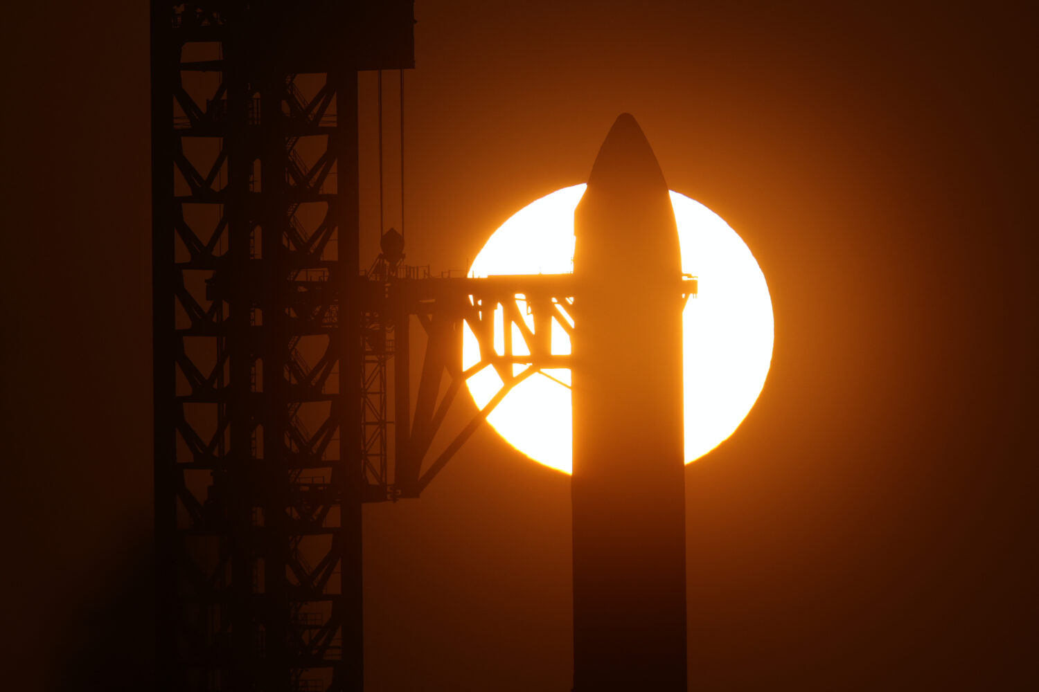 The sun rises behind SpaceX's mega rocket Starship as it is prepared for a test flight from Starbas...