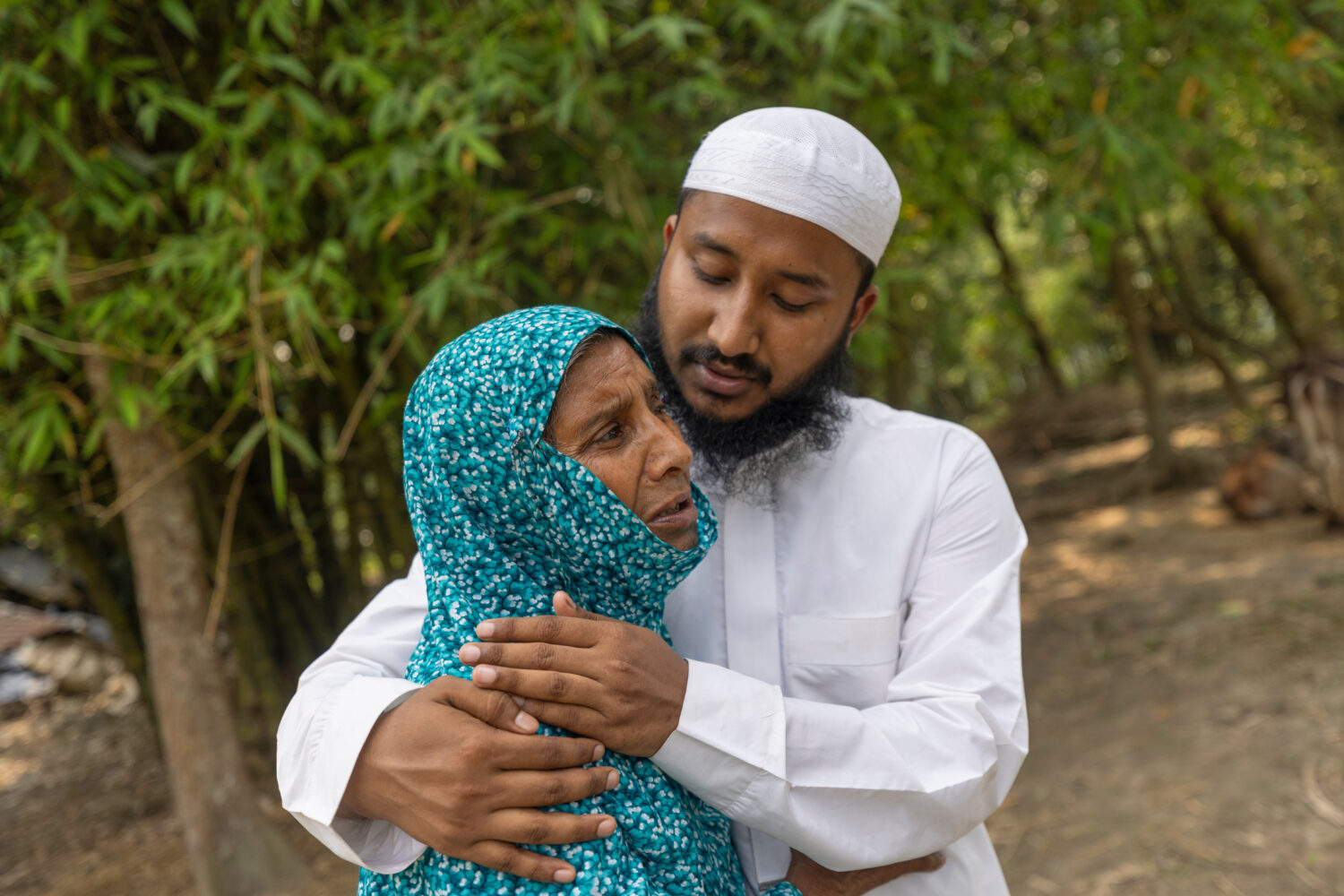 Maruf Hasan, brother of Mohammad Abdullah Al Mamun comforts his mother, Shahida Khatun, as she weep...