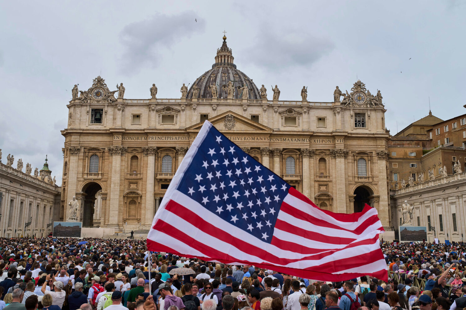 FILE - A flag from the United States waves in the crowd as Pope Leo XIV appears at the central balc...