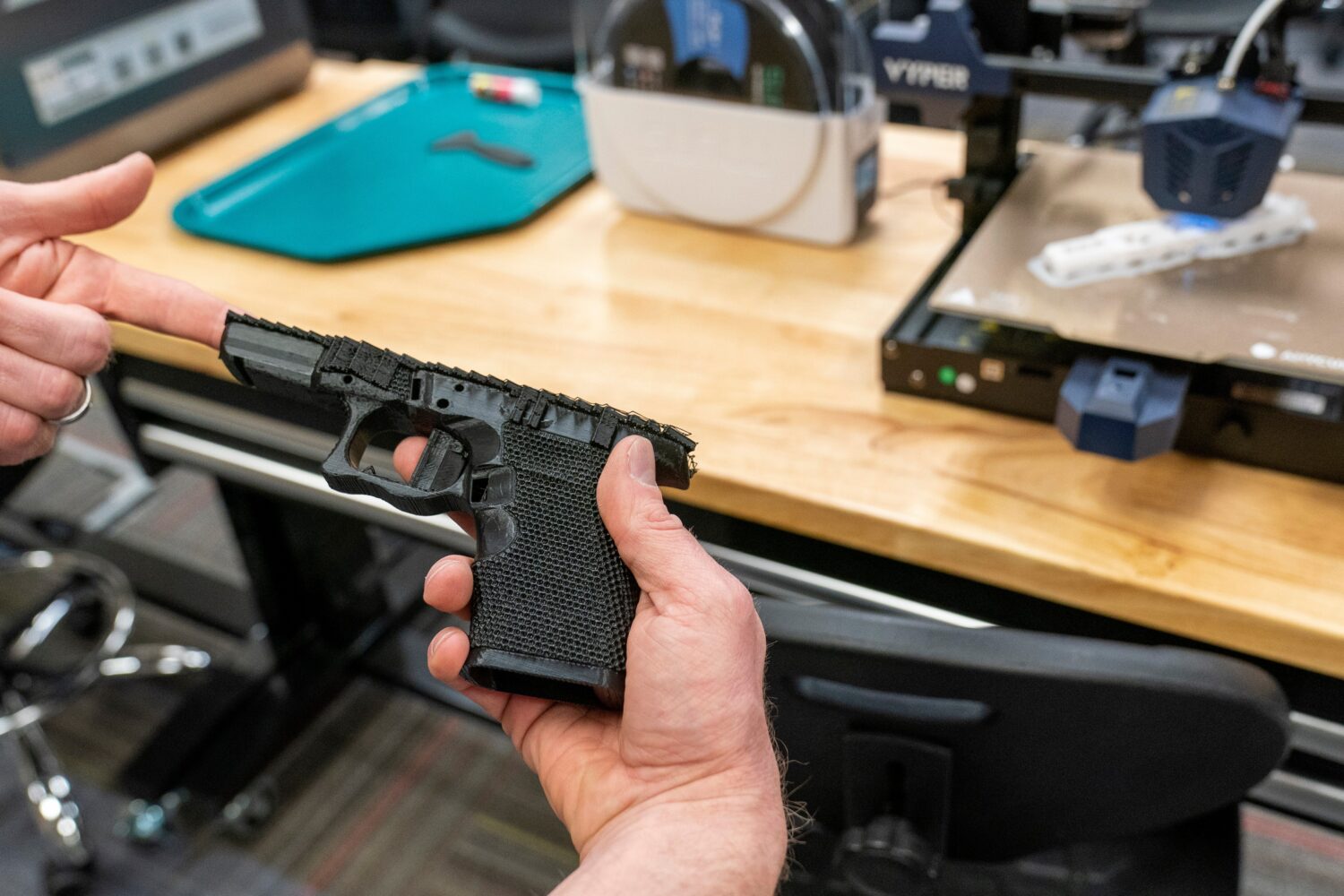 FILE - A handgun frame that has been printed on a 3D printer is held for a photograph at the Bureau...
