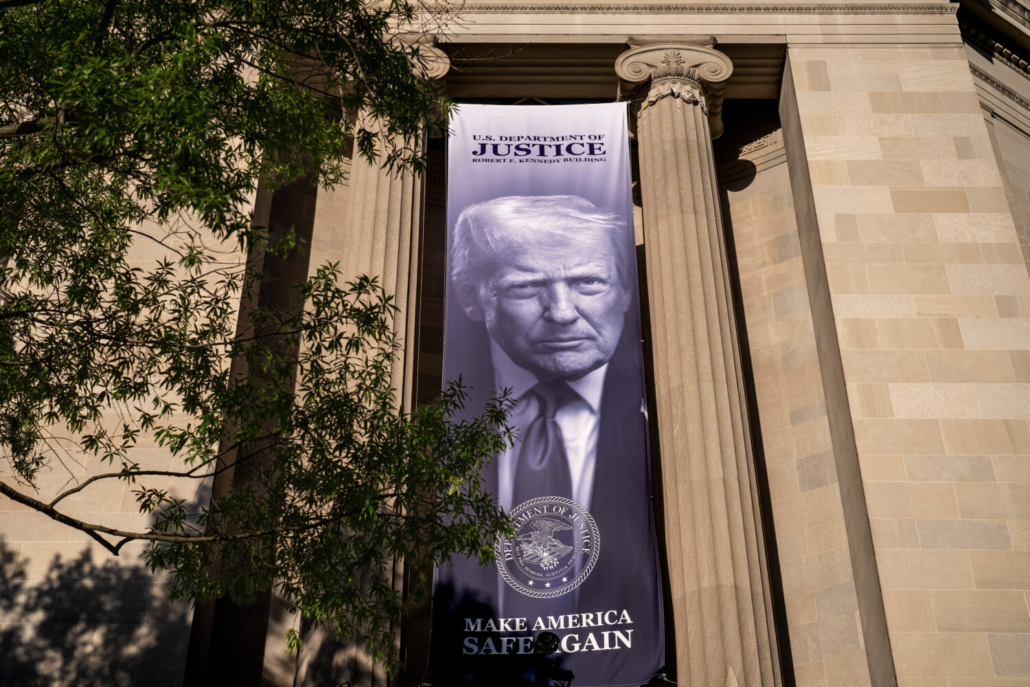A giant portrait of President Donald Trump looks down from the Justice Department in Washington, Tu...