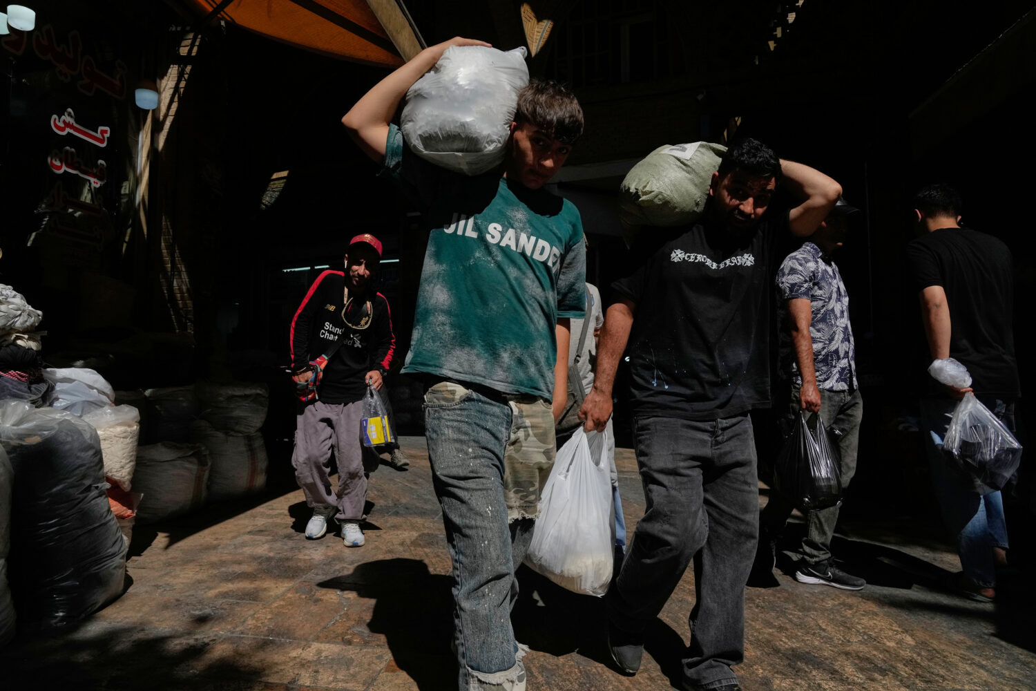 People carry packages at Tehran's historic Grand Bazaar, Iran, Monday, June 1, 2026. (AP Photo/Vahi...