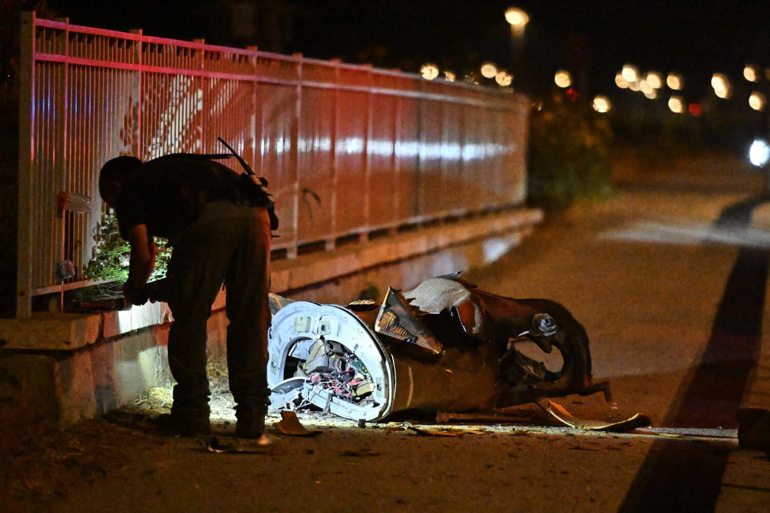 Israeli security forces examine a fragment of an intercepted Iranian missile in northern Israel, ea...