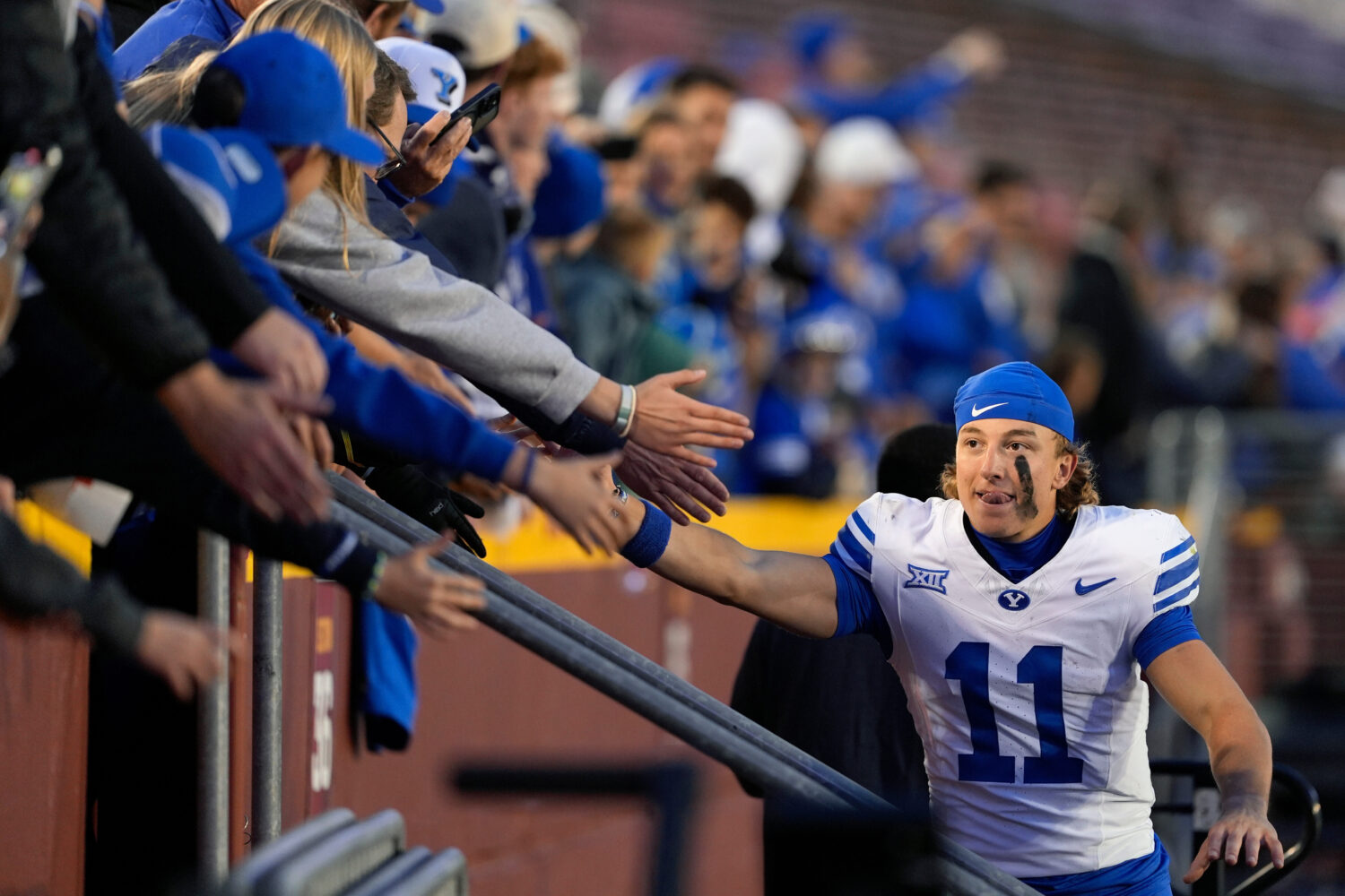 FILE - BYU wide receiver Parker Kingston (11) celebrates with fans after a win over Iowa State in a...