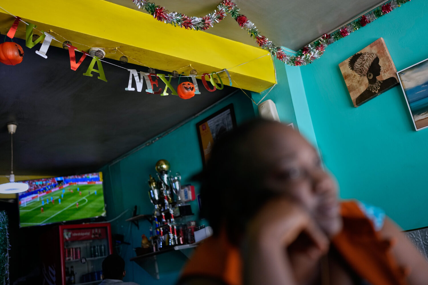 Vivianne Petit Frere looks on below a "viva Mexico" sign at her Haitian food restaurant, Lakou Laka...
