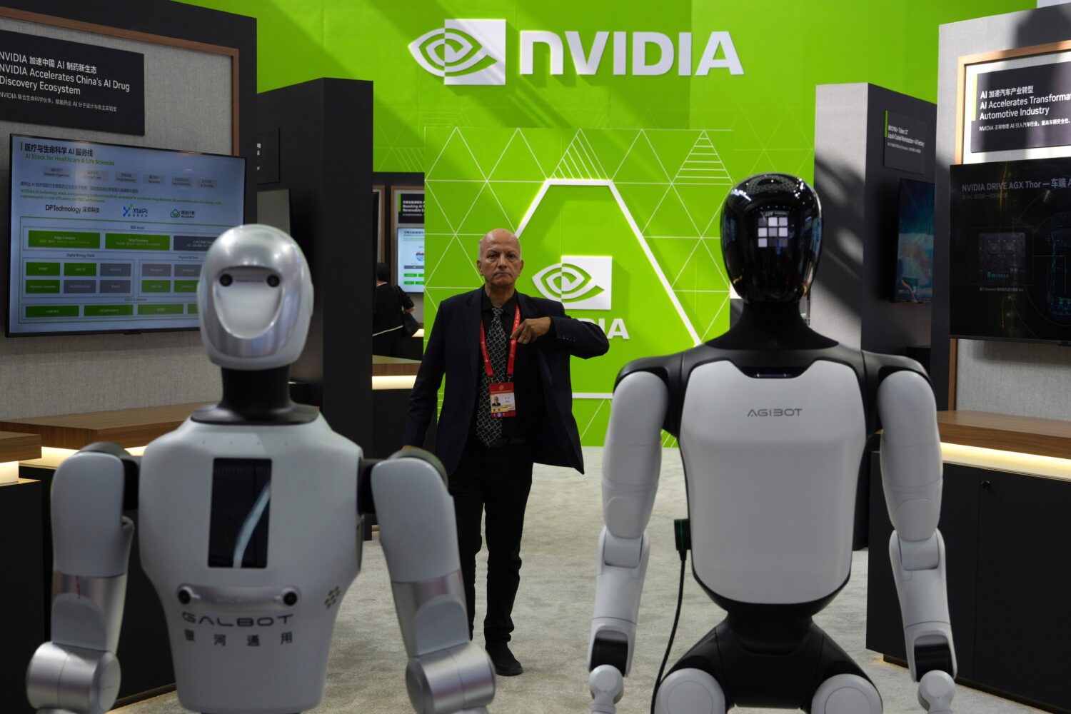 A worker stands near robots at the Nvidia booth during the China International Supply Chain Expo in...