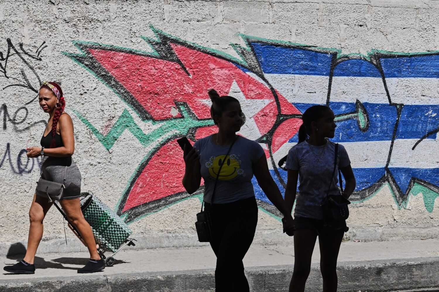 People walk past graffiti in the colors of the Cuban flag in Havana, Cuba, Wednesday, June 17, 2026...
