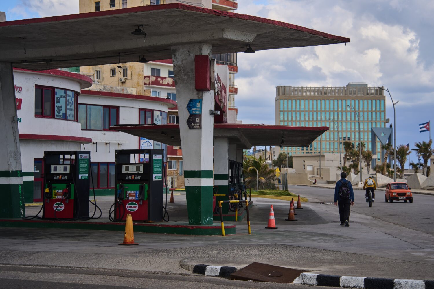 FILE - A man walks past a gas station that has run out of fuel, located near the U.S Embassy, pictu...