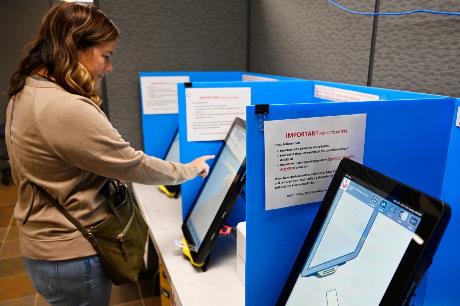 FILE- Courtney Parker votes on a new voting machine, in Dallas, Ga., Nov. 5, 2019. (AP Photo/Mike S...
